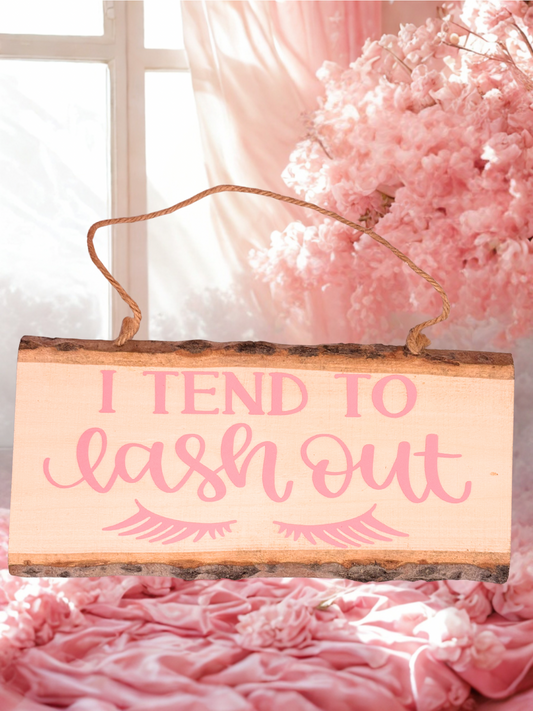 Rustic wooden plaque with the words I Tend To Lash Out and eyelashes in pink letters