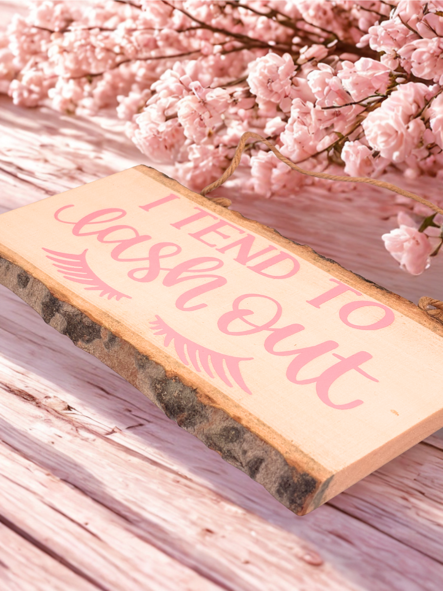 Rustic wood sign with pink eyelashes and text I Tend To Lash Out