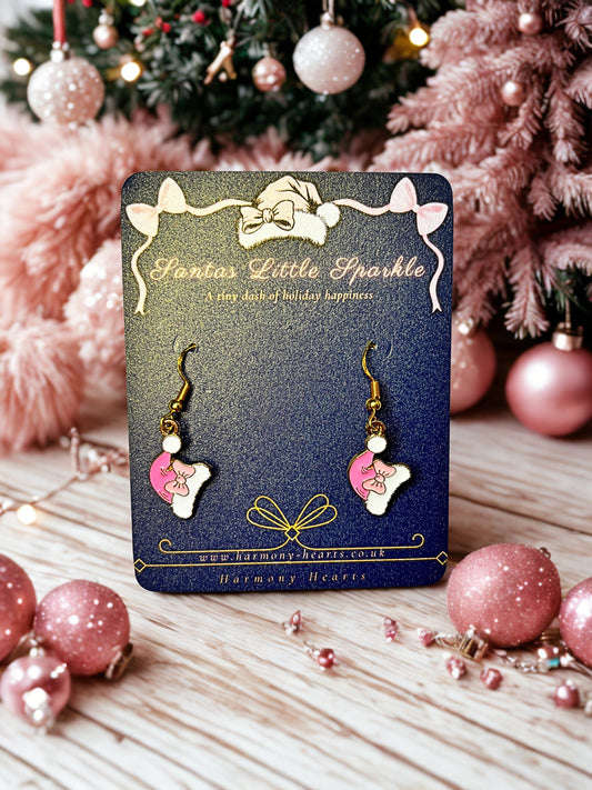 Pair of earrings on a 'Santa's Little Sparkle' card with Christmas decorations in the background.