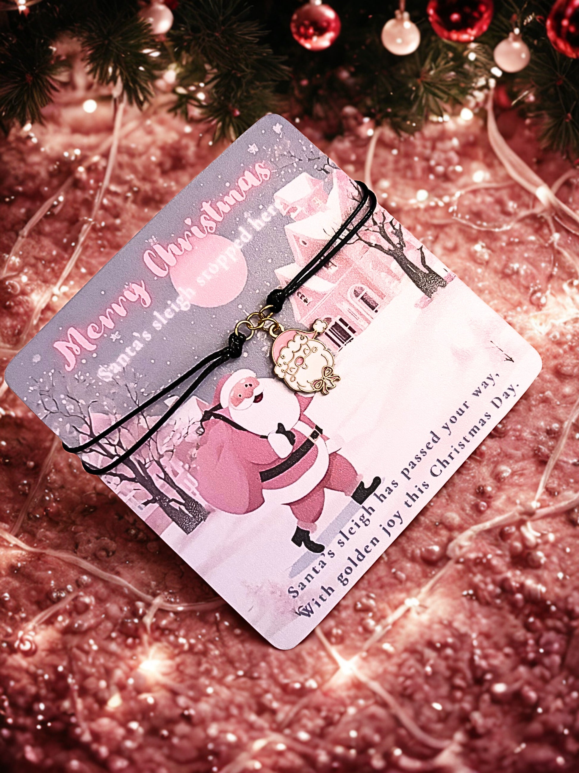 Christmas card with Santa Claus design and a santa charm bracelet on a glittery background