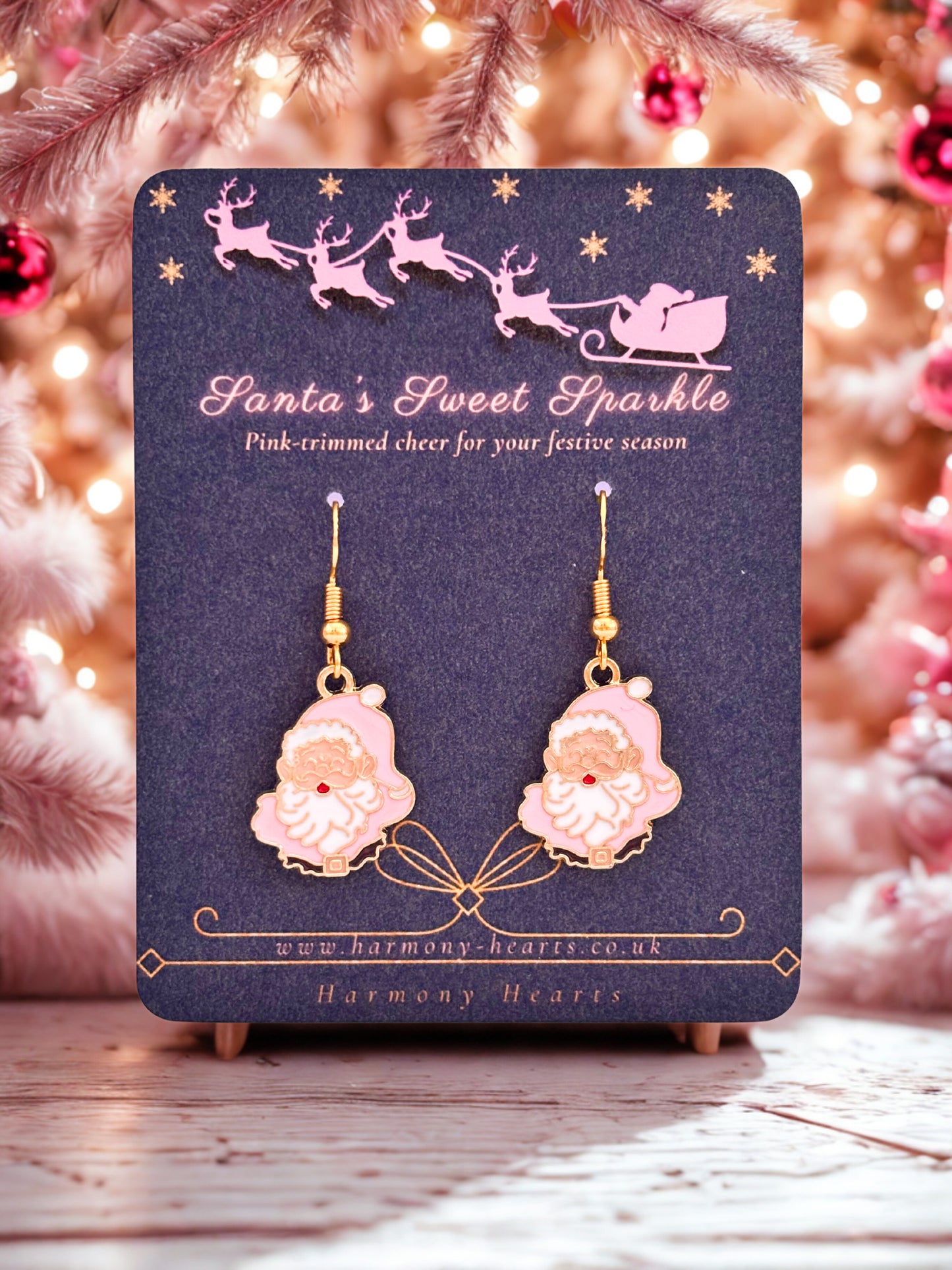 Pink Santa Claus earrings on a 'Santa's Sweet Sparkle' card with a festive background.