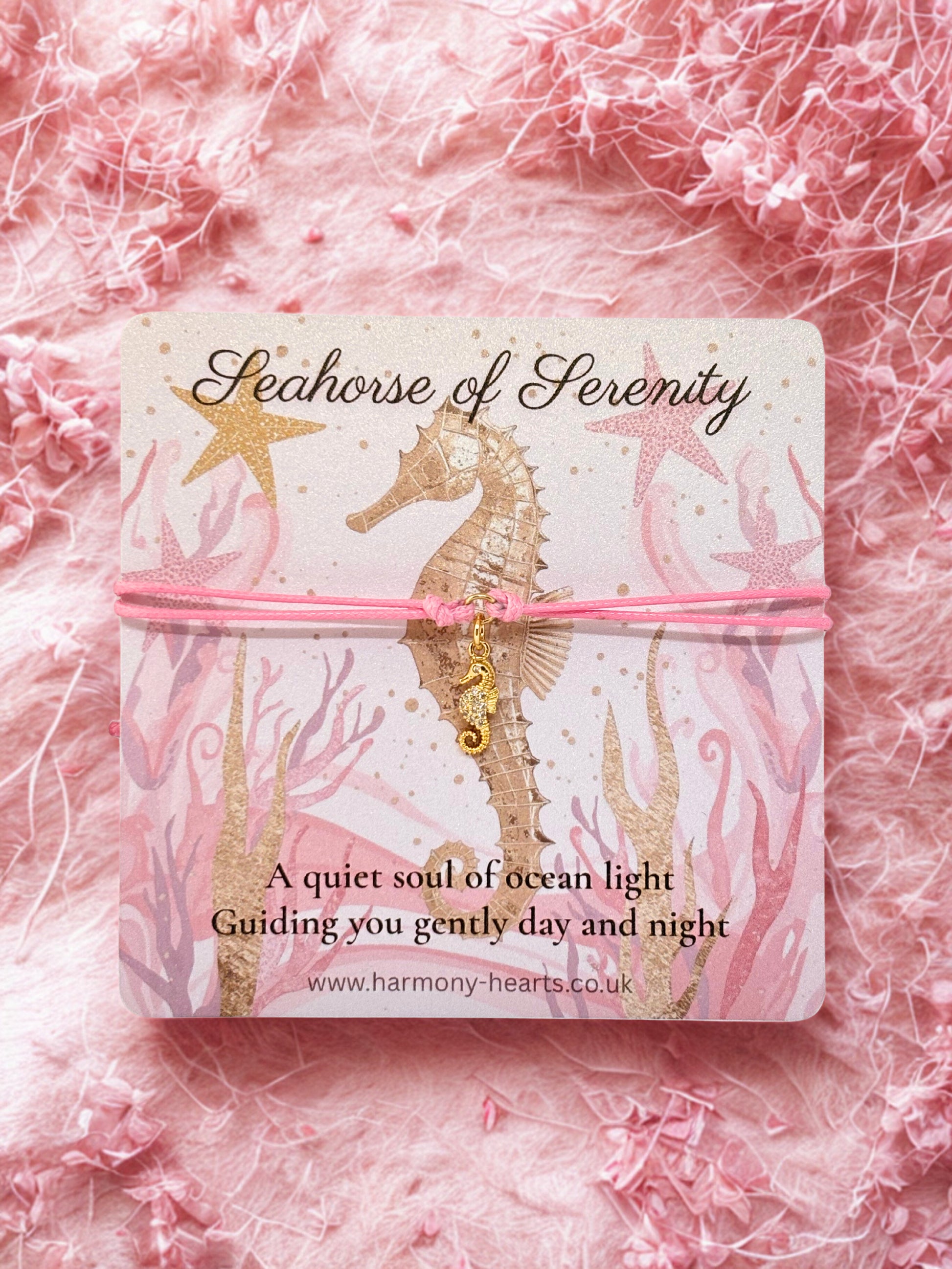 Seahorse charm on a pink background with 'Seahorse of Serenity' packaging.