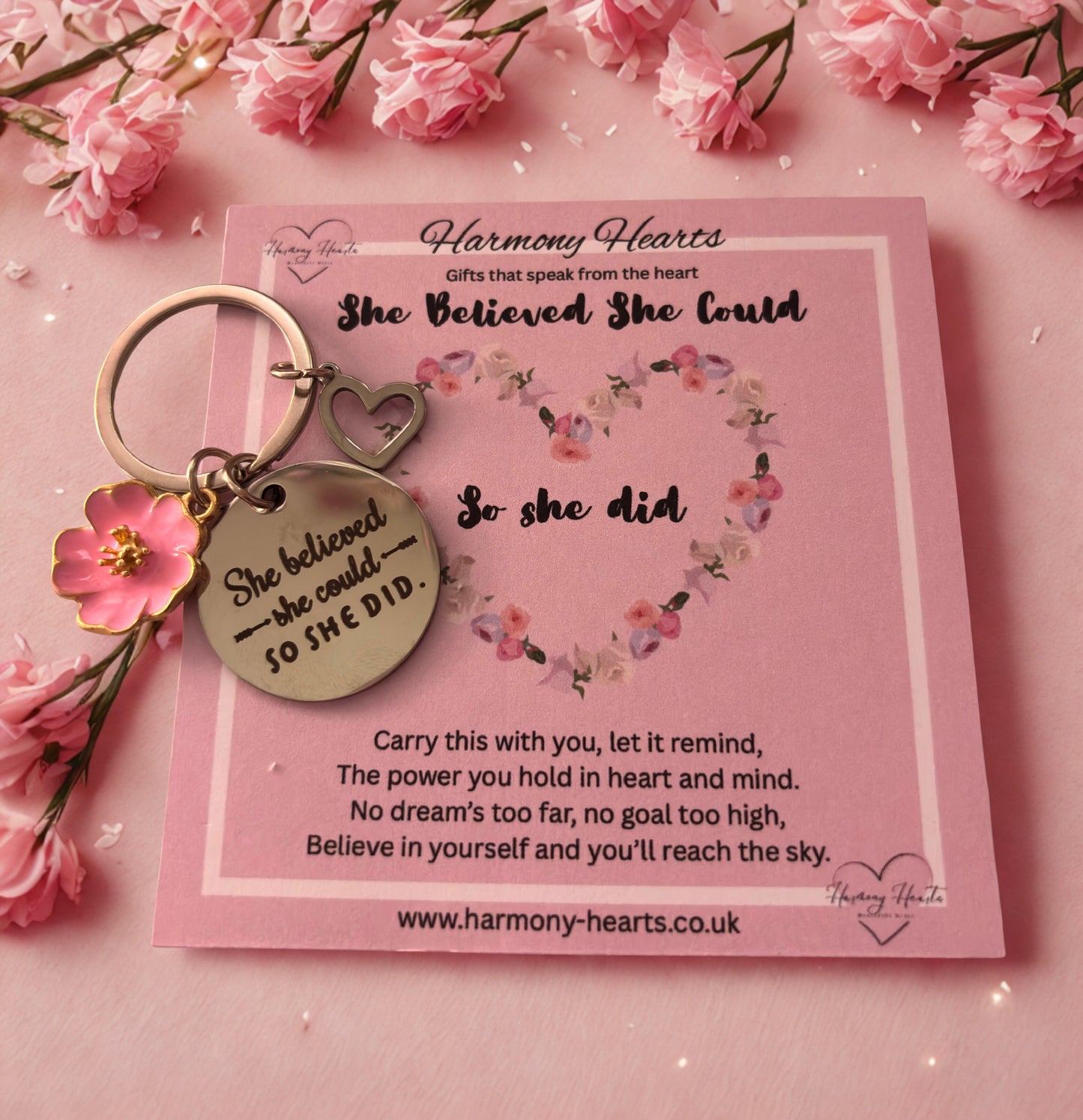 Keychain with motivational quote on a pink card surrounded by pink flowers