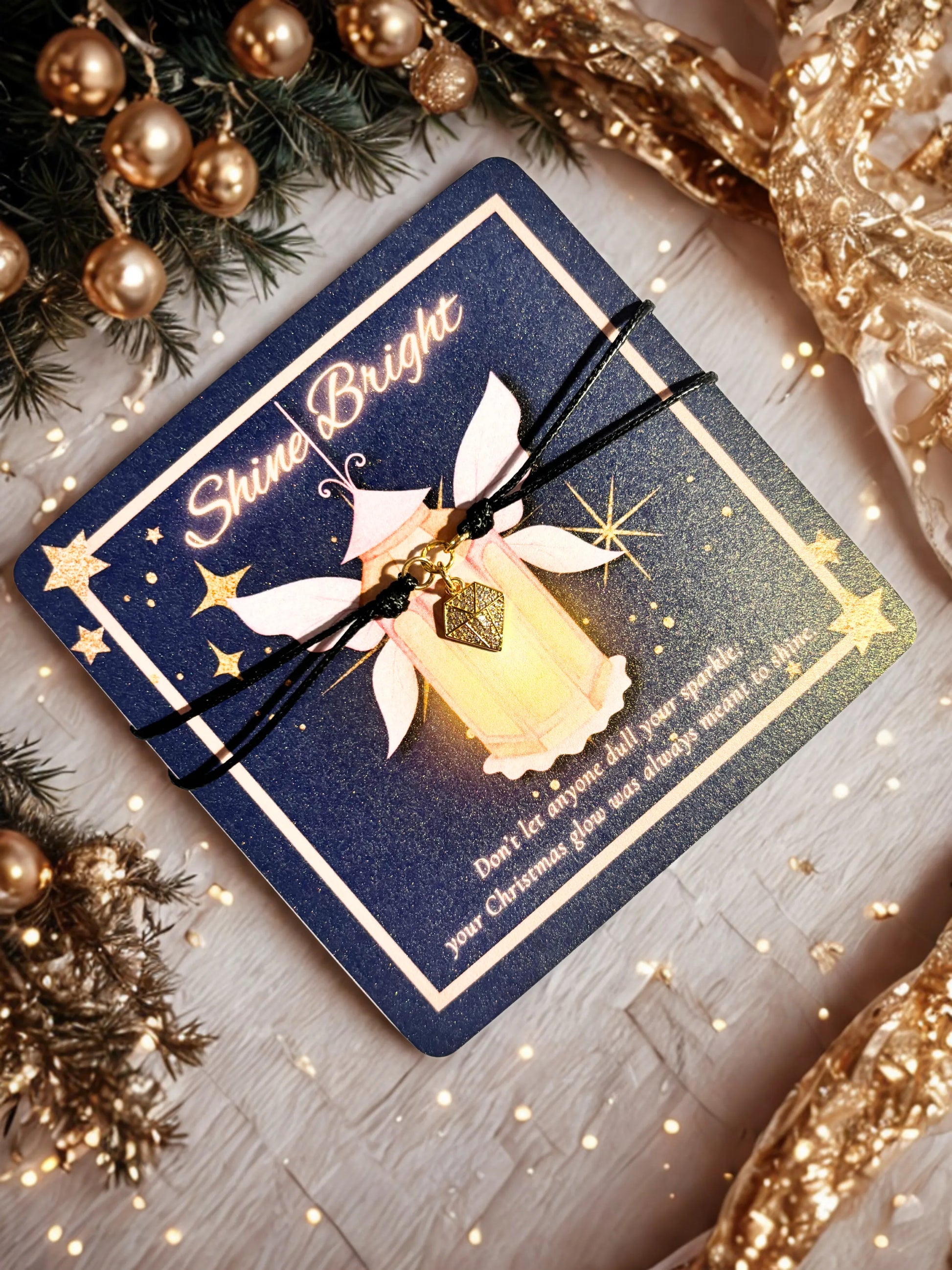 Glowing card with 'Shine Bright' text  and a charm bracelet surrounded by festive decorations