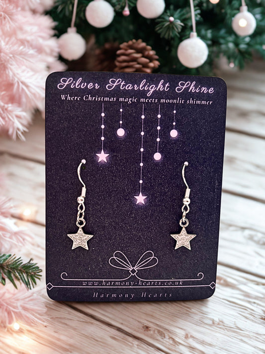Silver star sparkly earrings on a Harmony Hearts branded card with a Christmas background