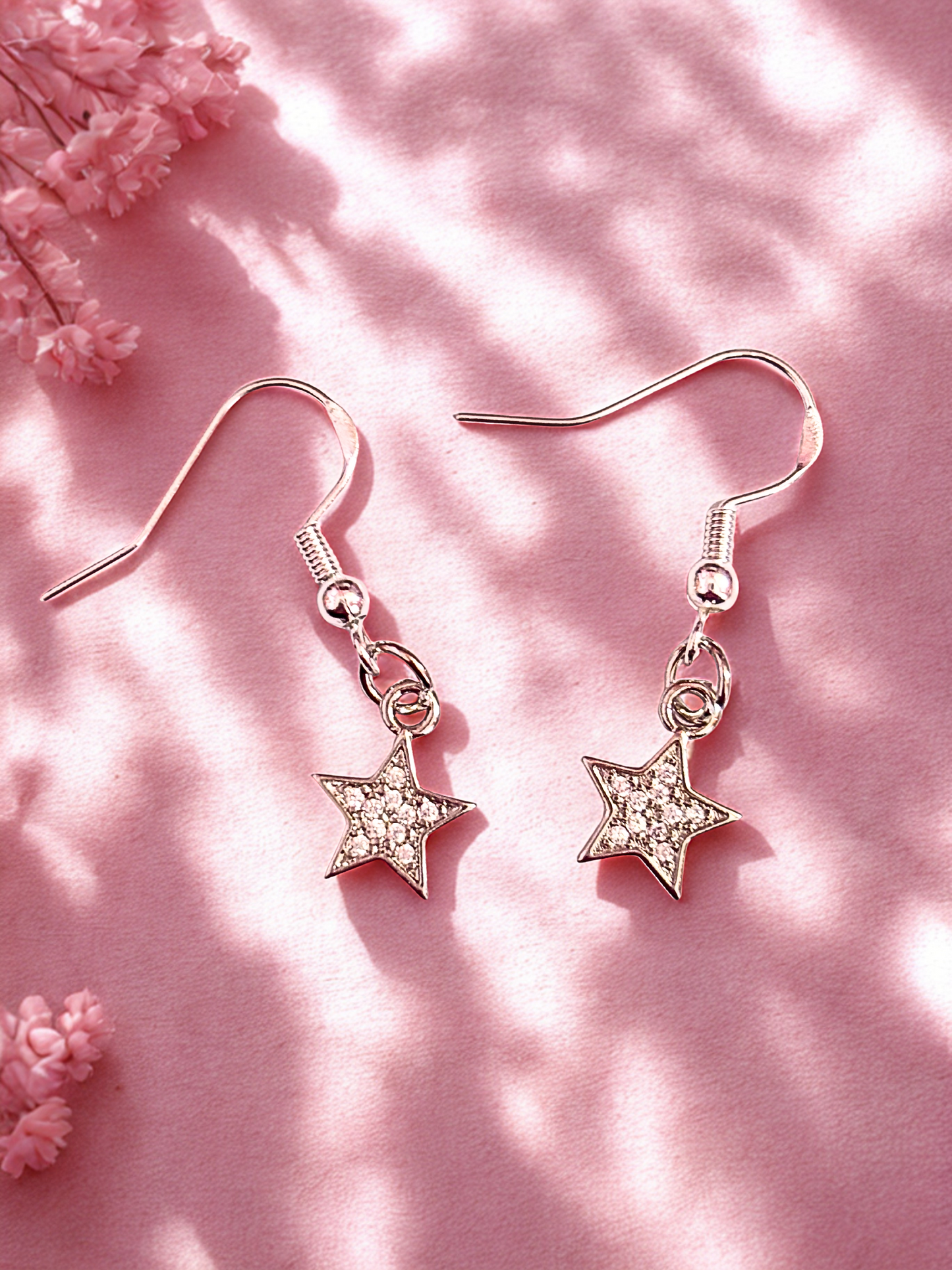 Silver star shaped earrings with sparkly stones on silver hooks