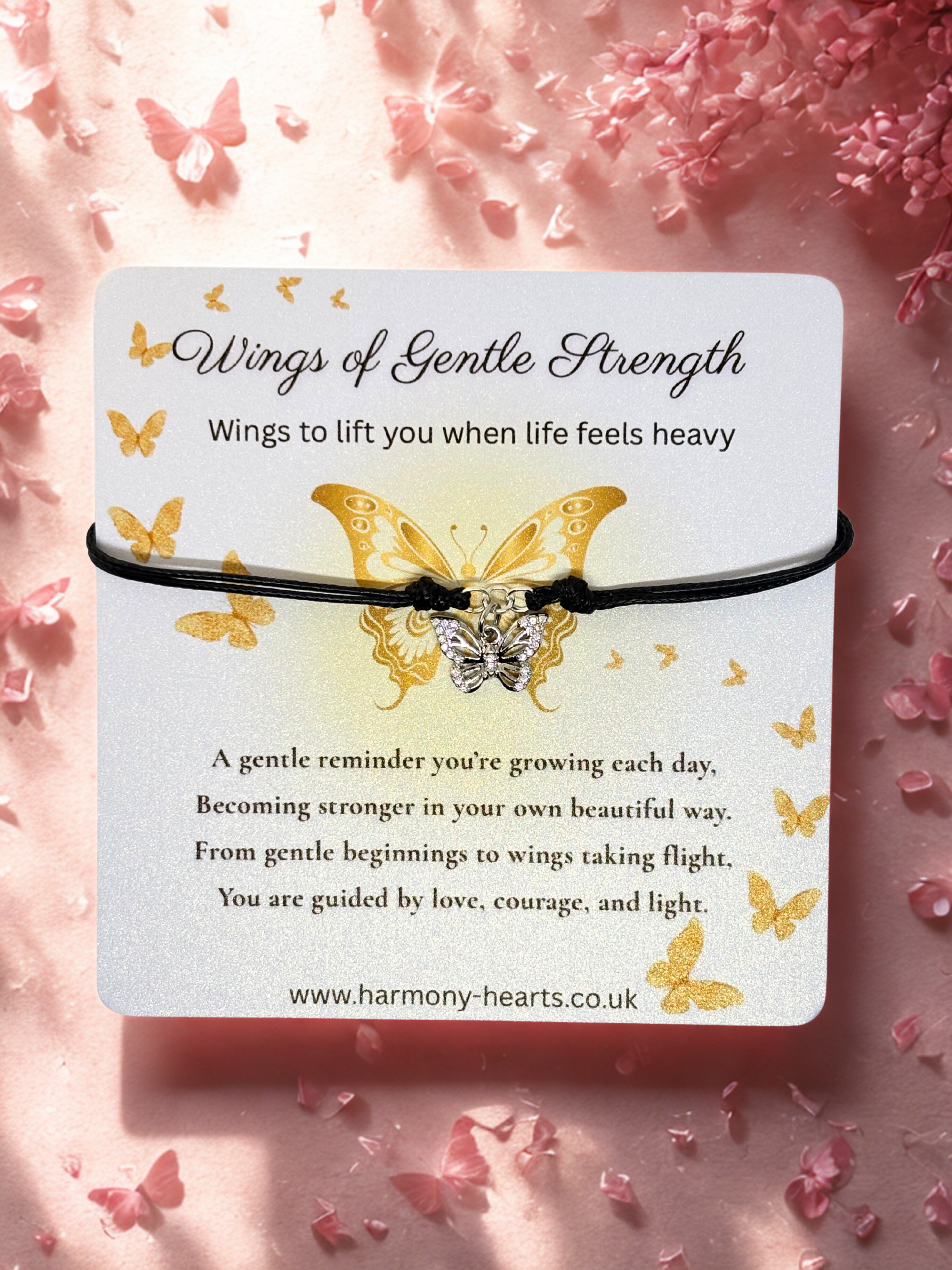 Butterfly bracelet on a card with text 'Wings of Gentle Strength' on a pink floral background.