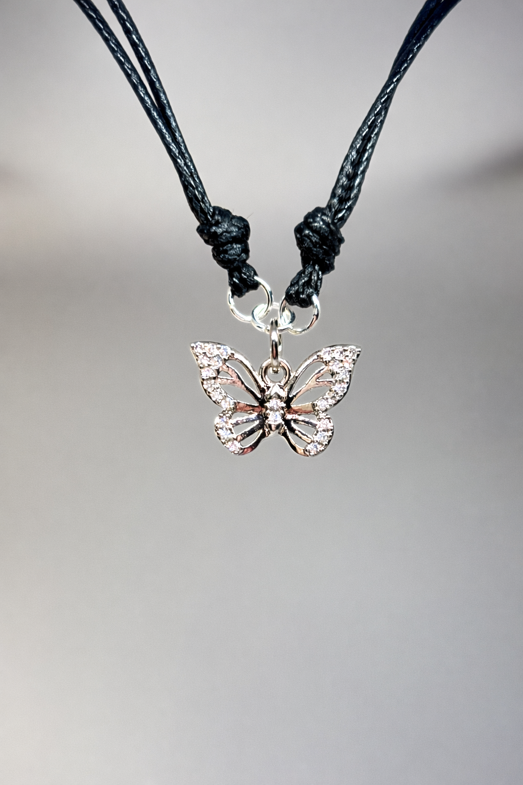 Butterfly charm bracelet on a gray background
