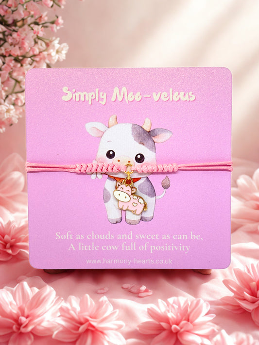 Pink cord bracelet with pink cow charm on a pink branded Harmony Hearts card with a cow illustration