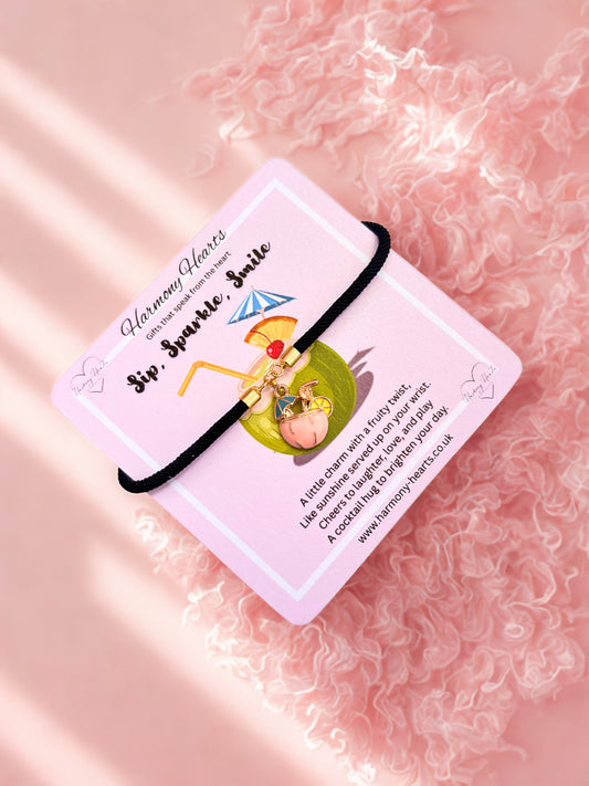 Charm bracelet with a card on a pink textured background