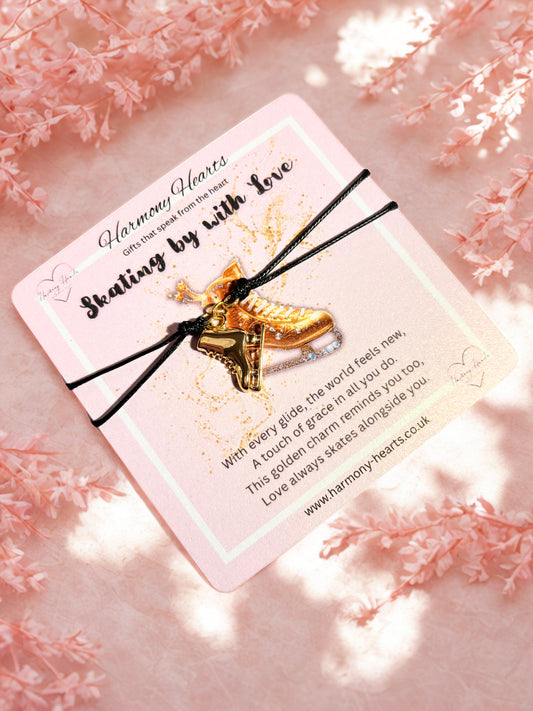 Gold ice skate charm on a pink card with floral background