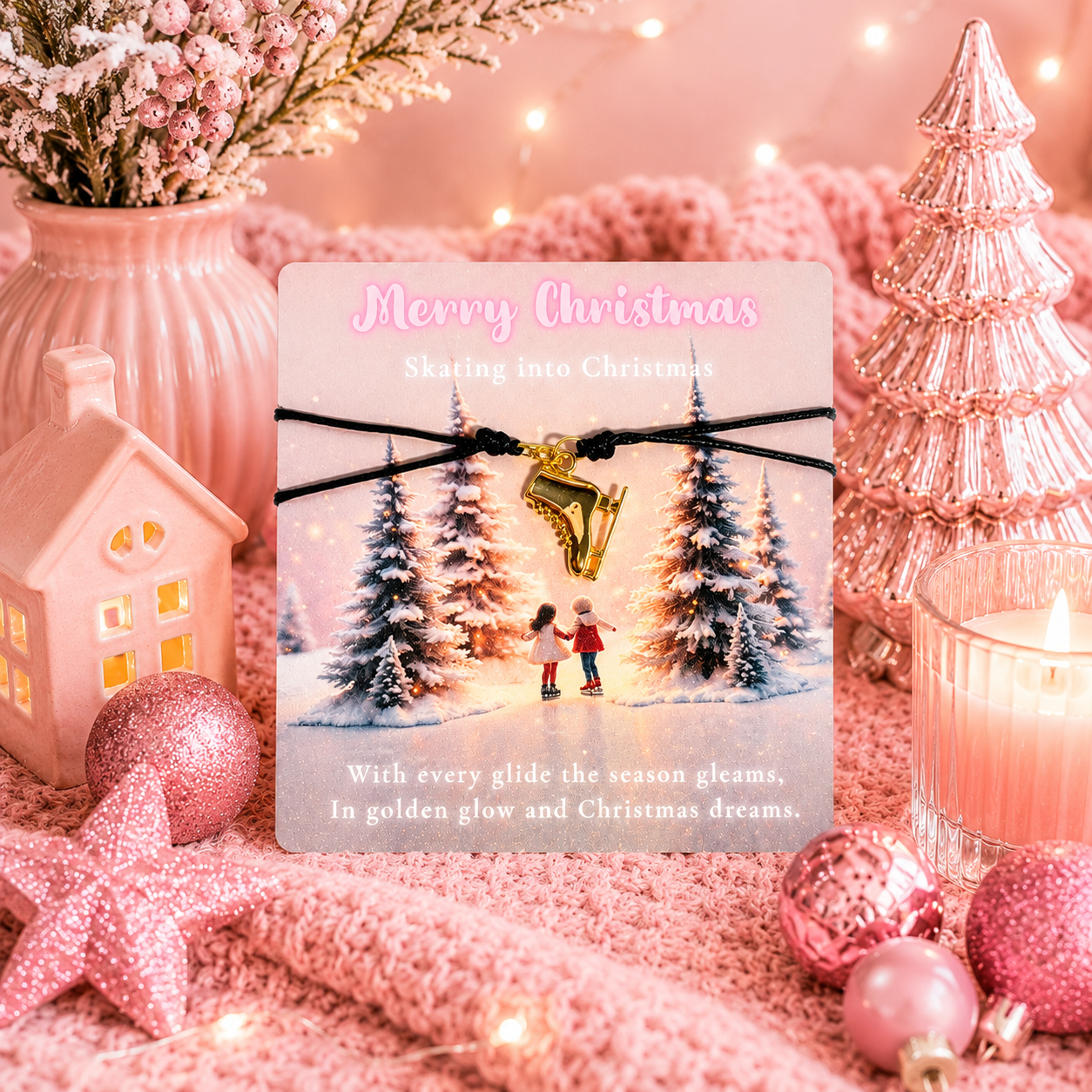 A Christmas-themed card displayed on pink holiday decor. The card reads 'Merry Christmas' and 'Skating into Christmas,' with a black cord bracelet across the front holding a gold ice skate charm.