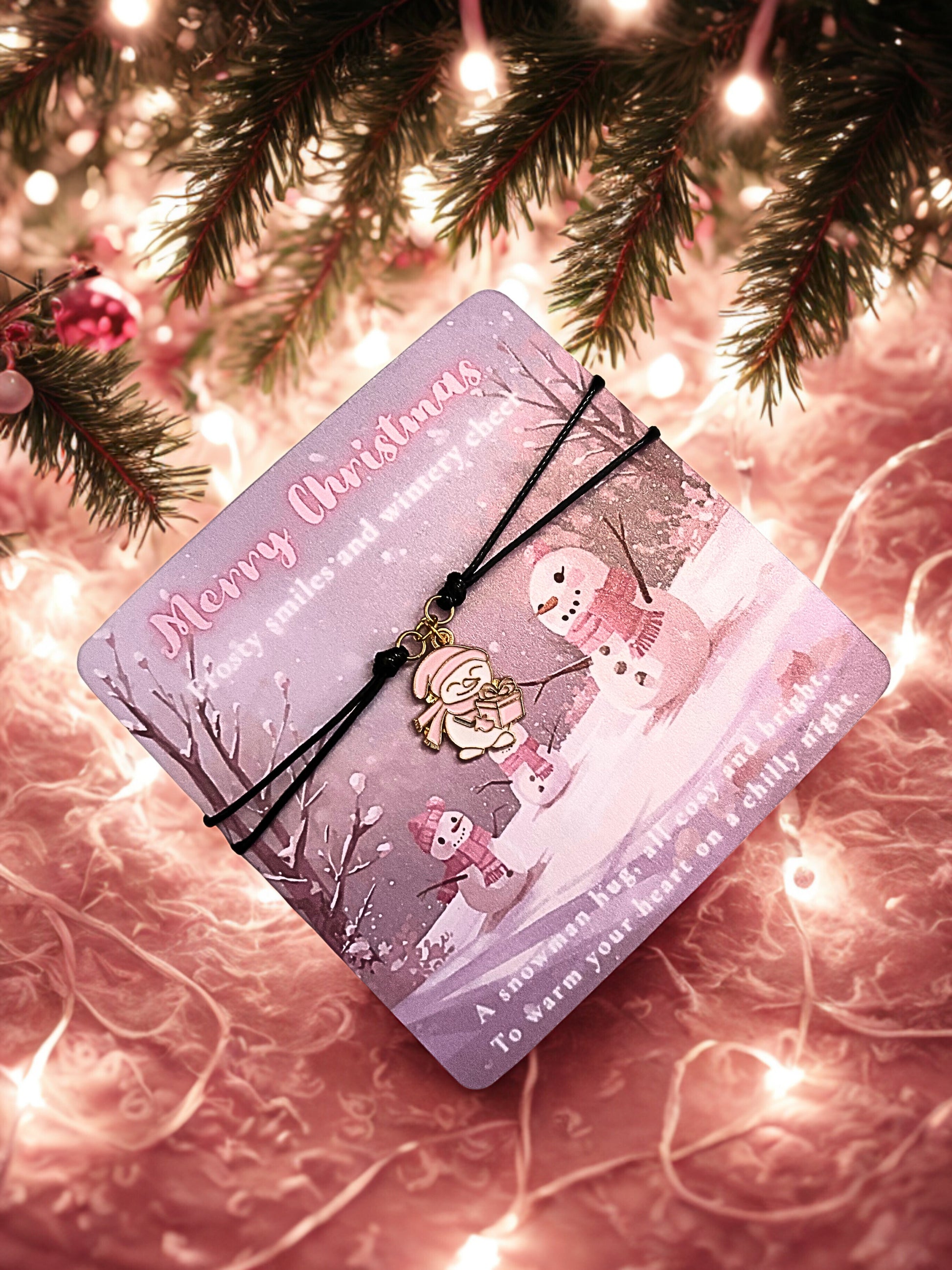 Pink Christmas card with snowman design on a festive background and a snowman charm bracelet