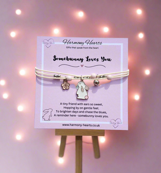 Bracelet with bunny design on a stand against a soft pink background with lights.