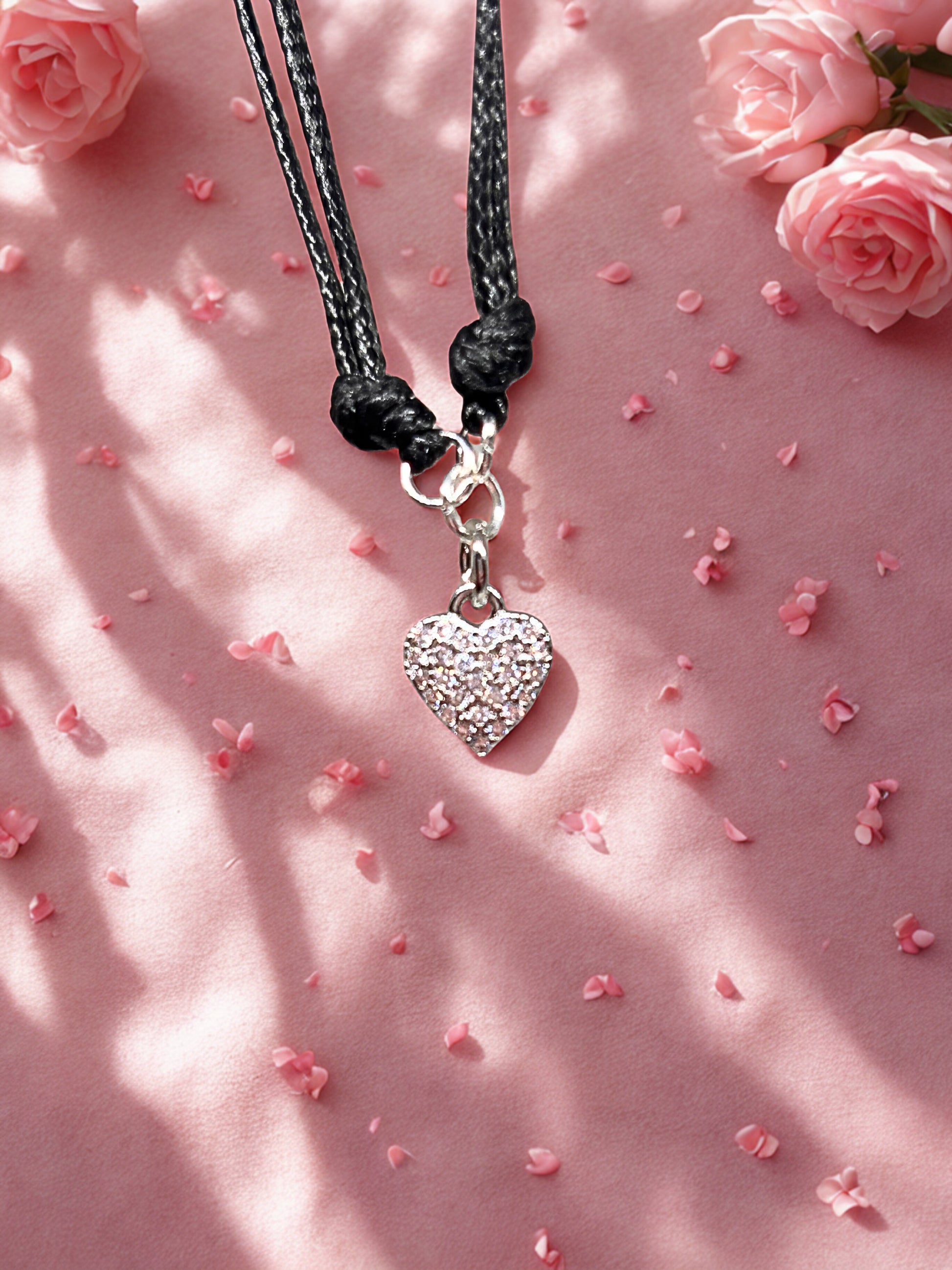 Bracelet  with a heart-shaped charm on a pink background with flowers