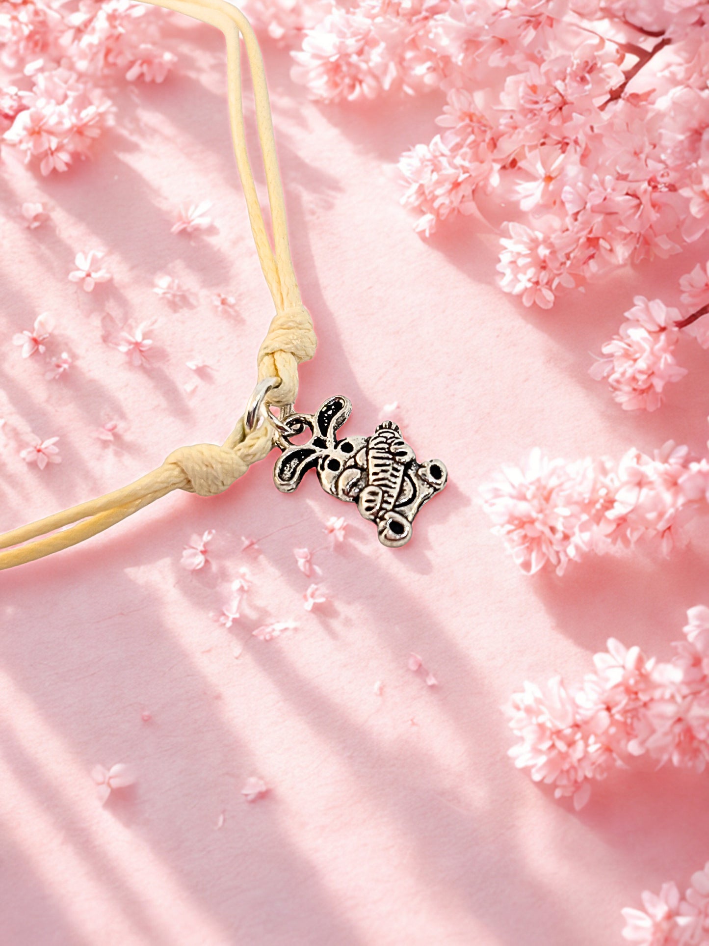 Bracelet with a bunny charm on a pink floral background