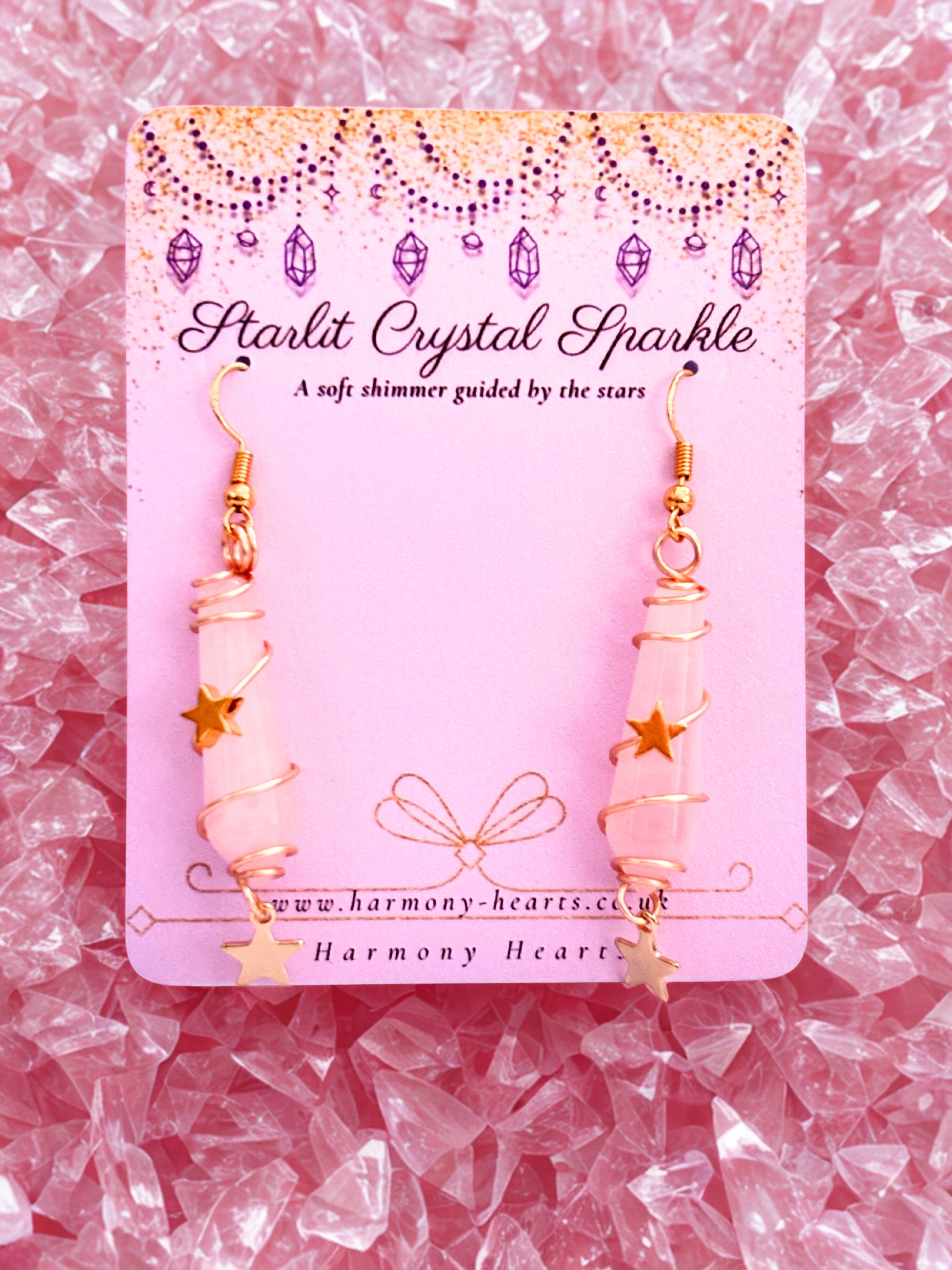 Pink crystal earrings on a pink card with 'Starlit Crystal Sparkle' text, surrounded by pink crystals.