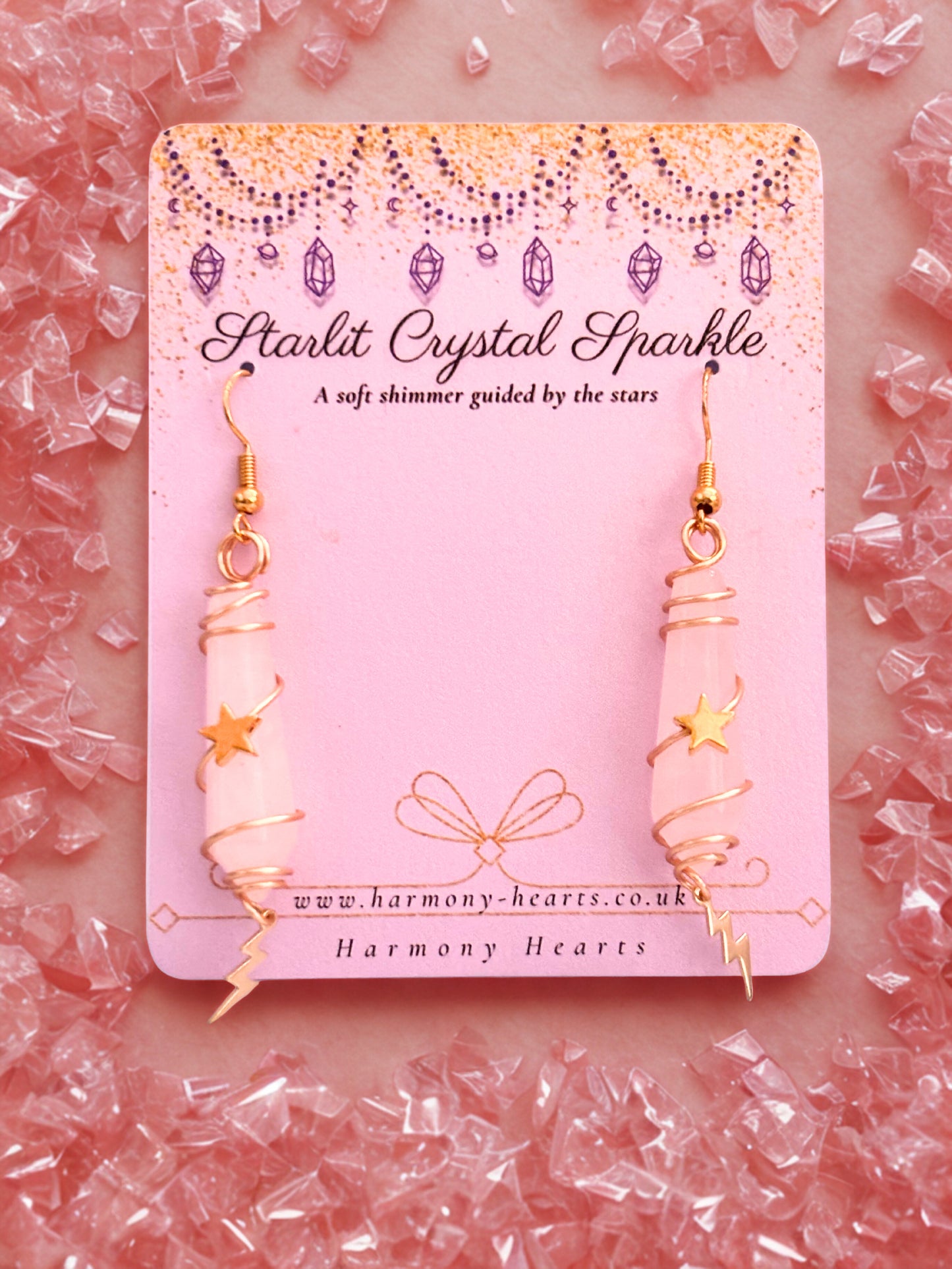 Earrings on a 'Starlit Crystal Sparkle' card with pink gemstones in the background