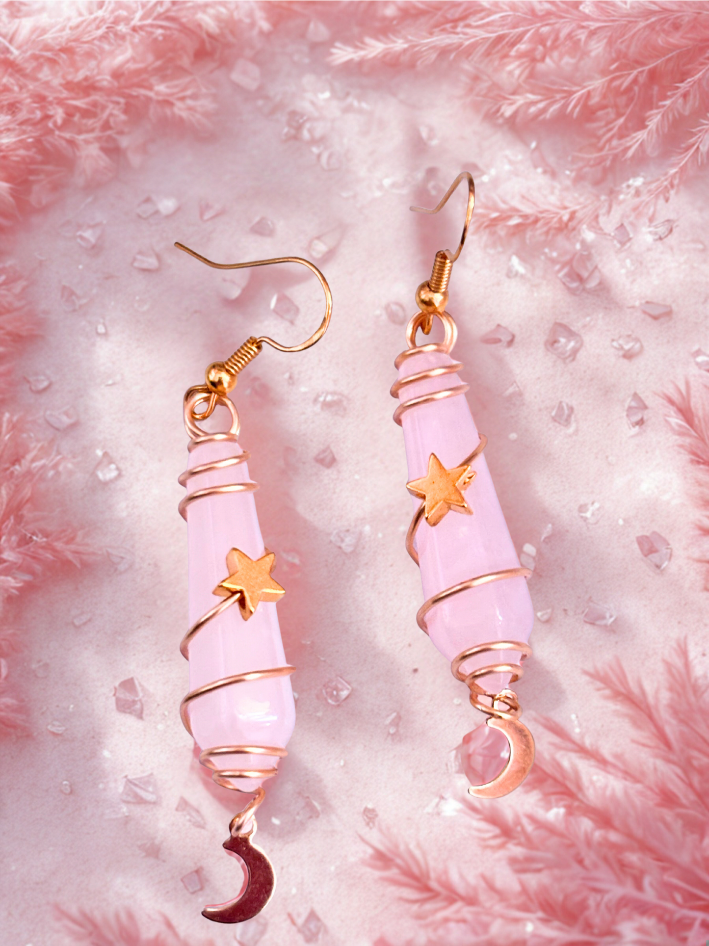 Pink rose quartz earrings with gold accents on a pink textured background