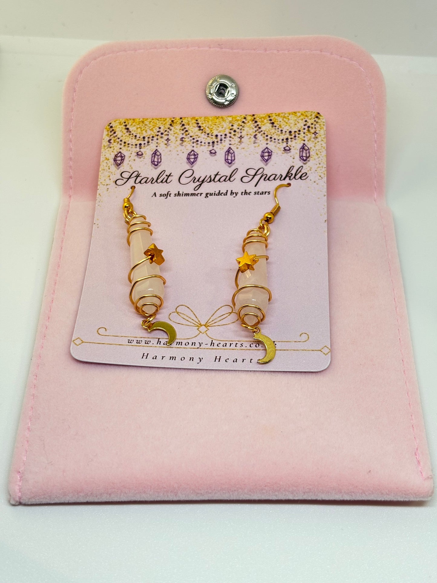 Pair of earrings on a 'Harmony Hearts' card with a pink case.