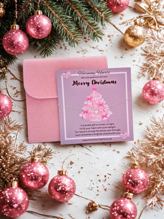 Pink jewelry pouch with a card and Christmas decorations on a light surface