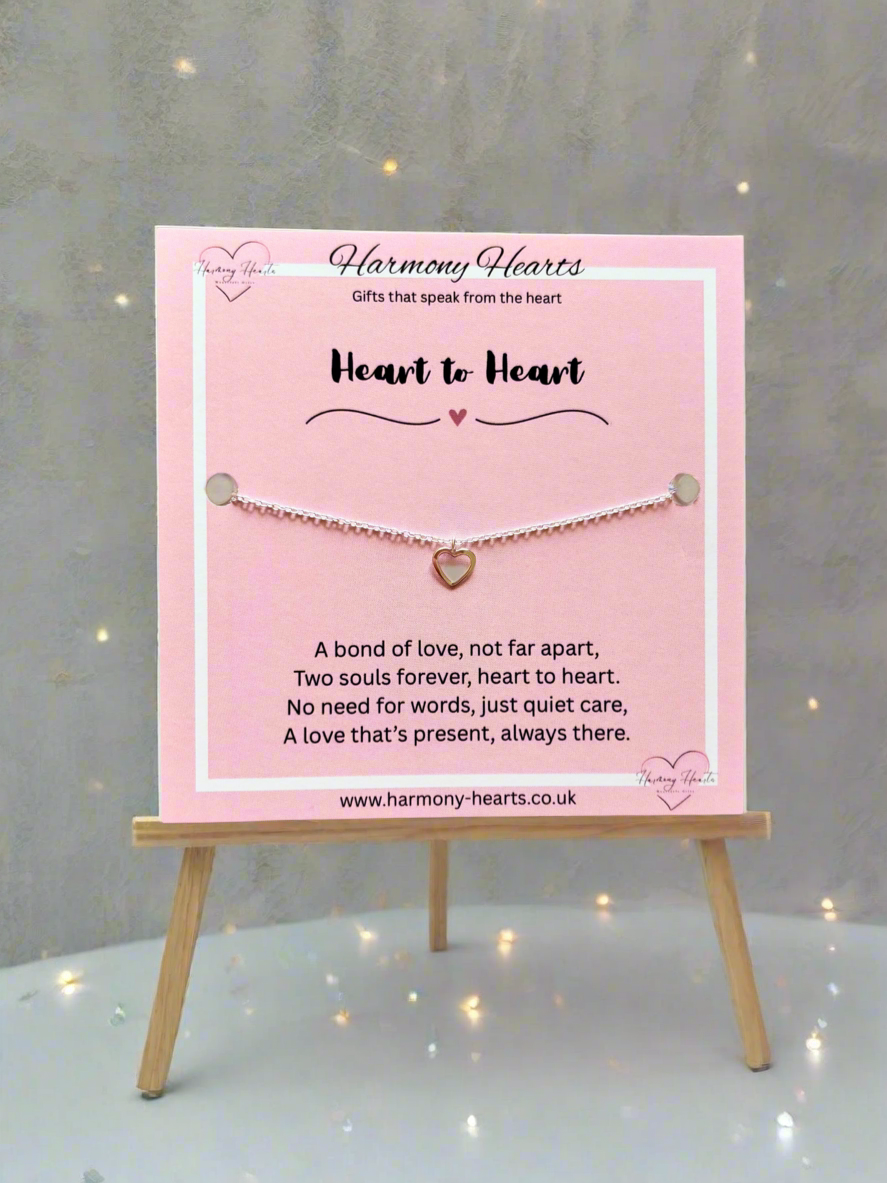 Bracelet on a pink card with 'Harmony Hearts' branding, displayed on a small wooden stand.