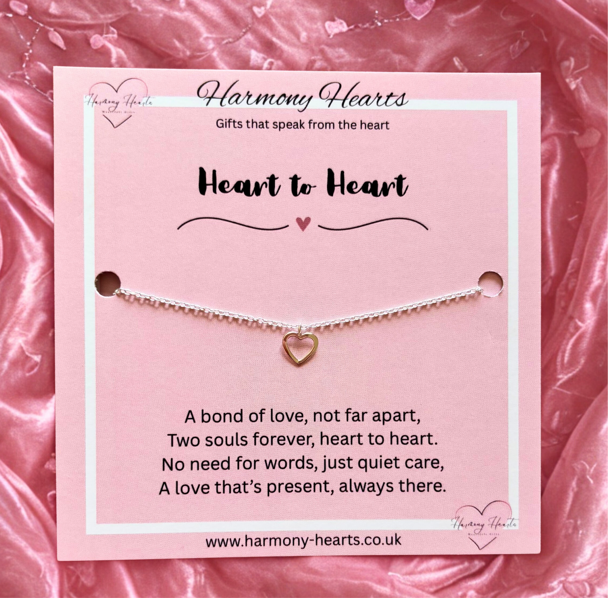 Jewelry card with a heart-shaped bracelet on a pink fabric background, featuring 'Harmony Hearts' branding.
