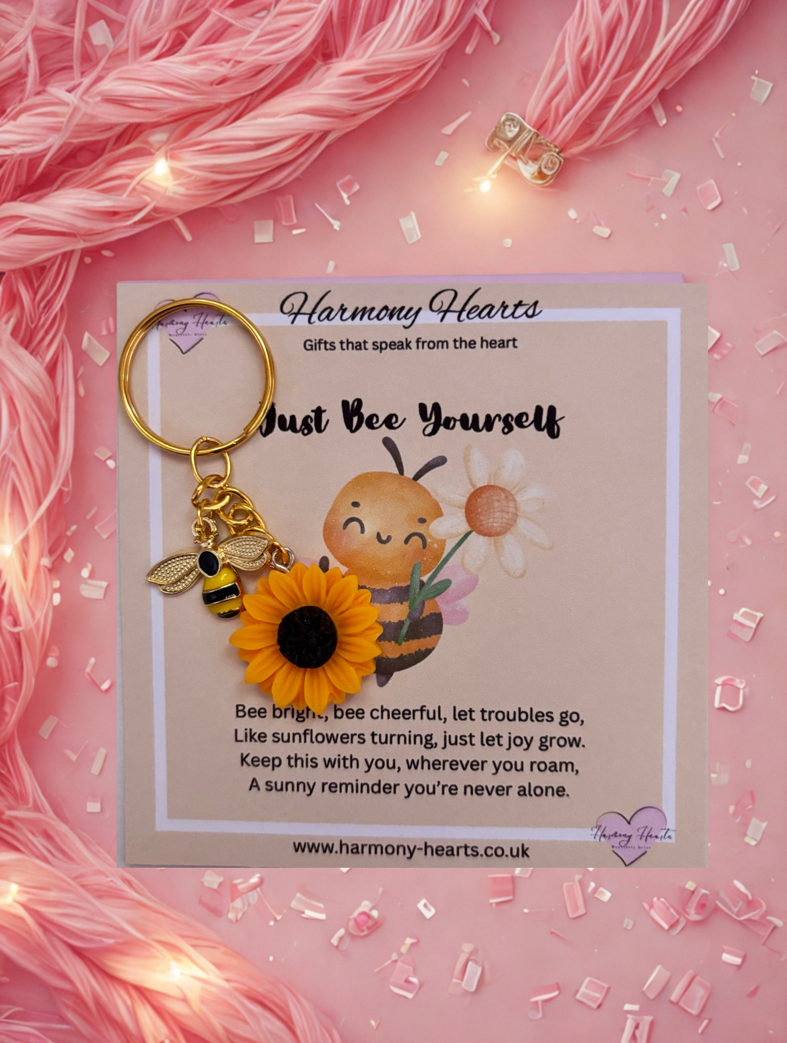 Keychain with bee and sunflower design on a pink background with 'Harmony Hearts' branding.