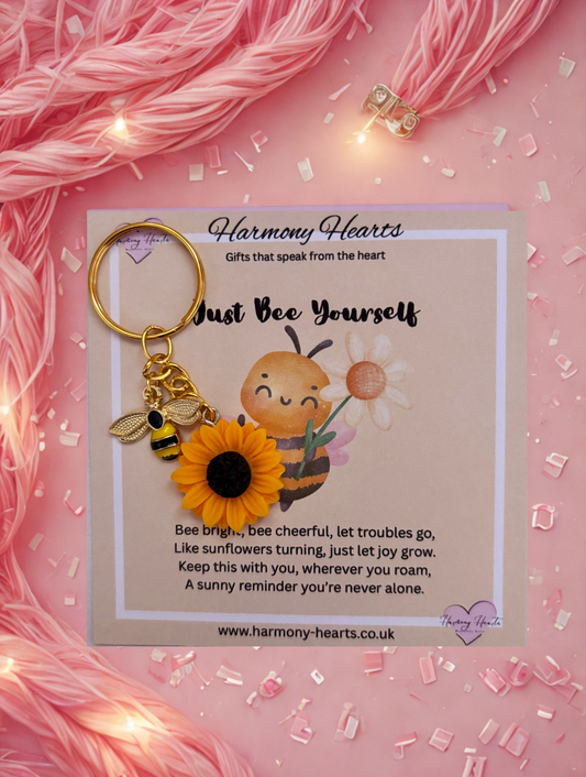 Keychain with bee and sunflower design on a pink background with 'Harmony Hearts' branding.