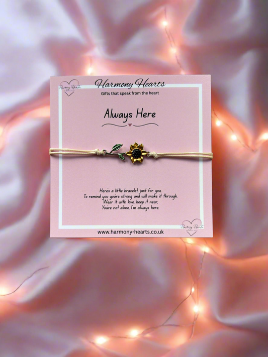 Bracelet on a pink card with 'Harmony Hearts' branding, set against a soft pink background with string lights.