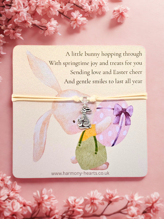 Easter themed card with a bunny design and and bunny charm bracelet on a cherry blossoms pink background
