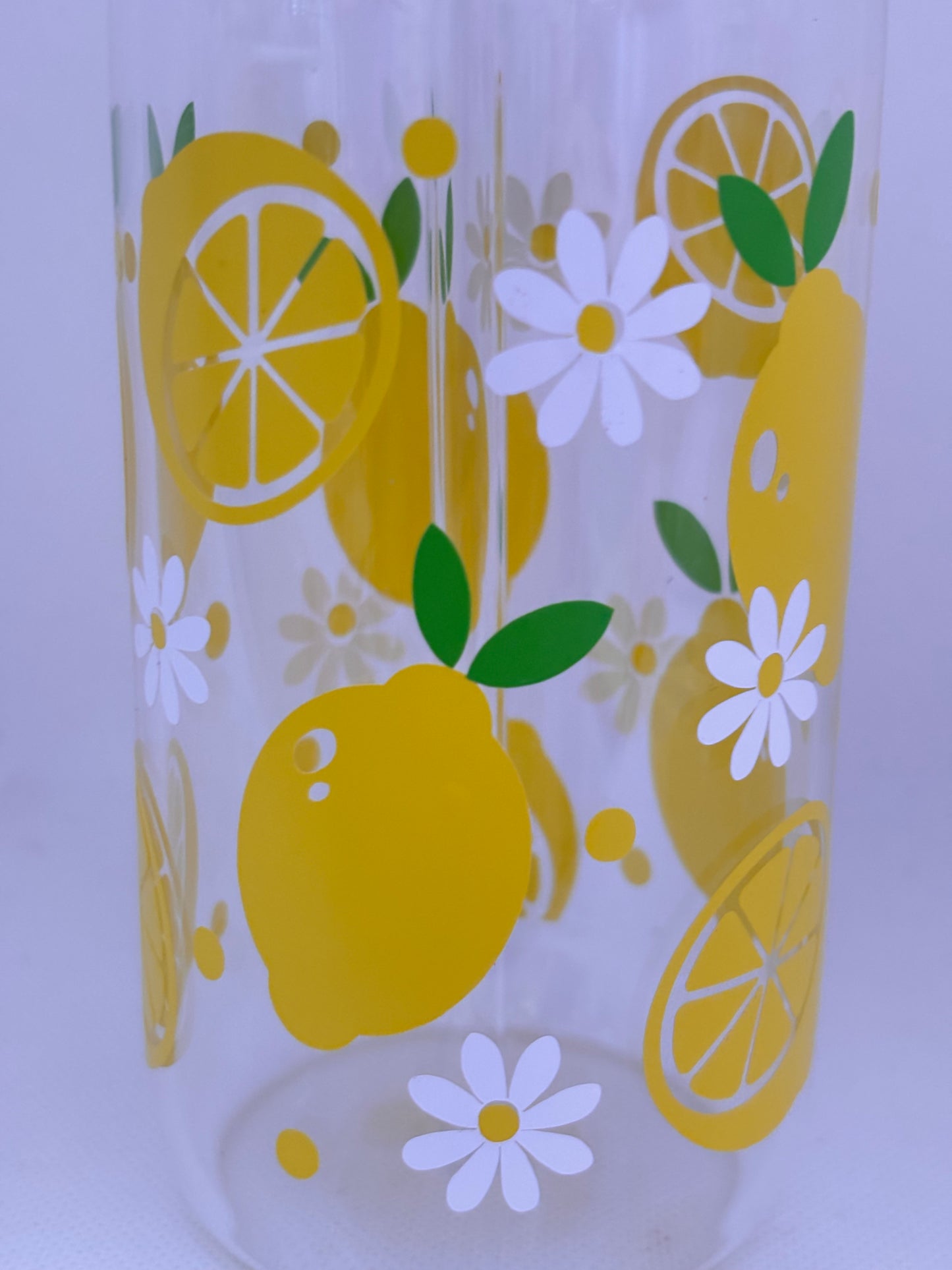 Glass with lemon and daisy pattern on a white background