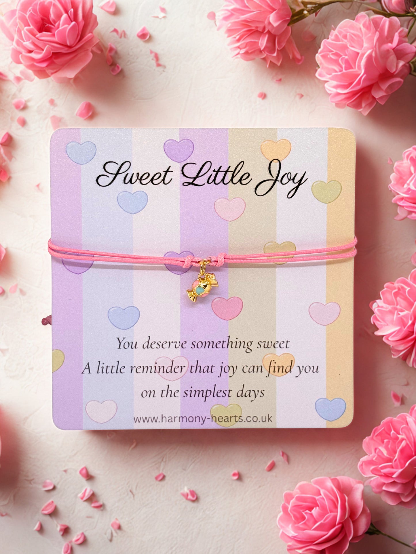 Pink cord bracelet with a gold and enamel sweet charm presented on a branded Harmony Hearts card