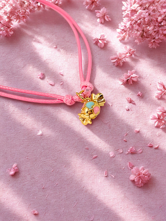 Gold sweet charm on a pink cord bracelet