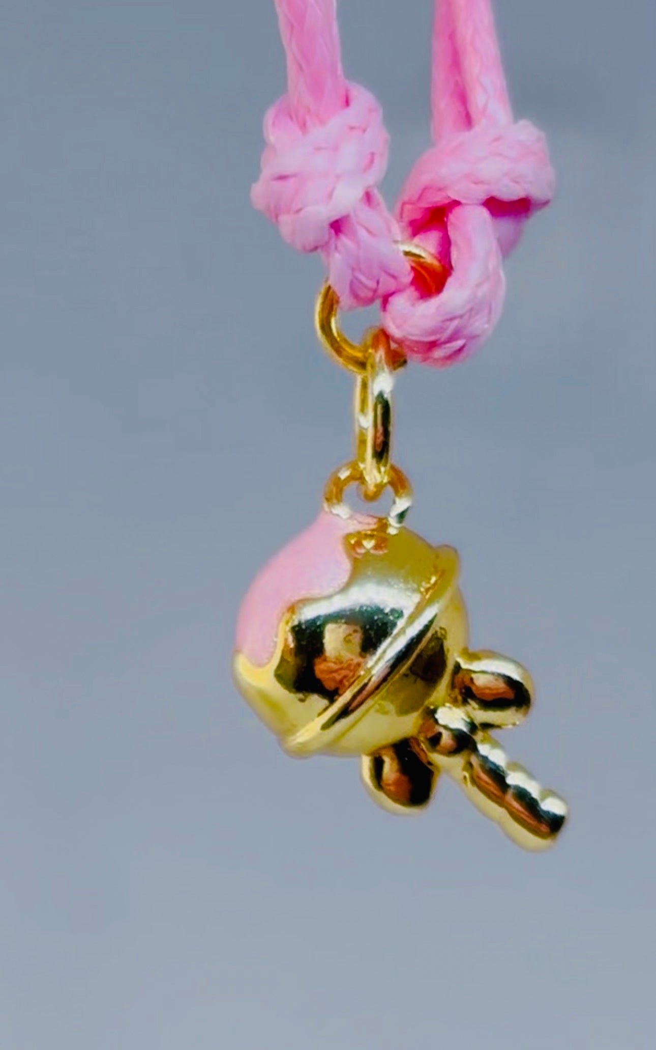 Pink and gold sweet charm on a pink bracelet cord