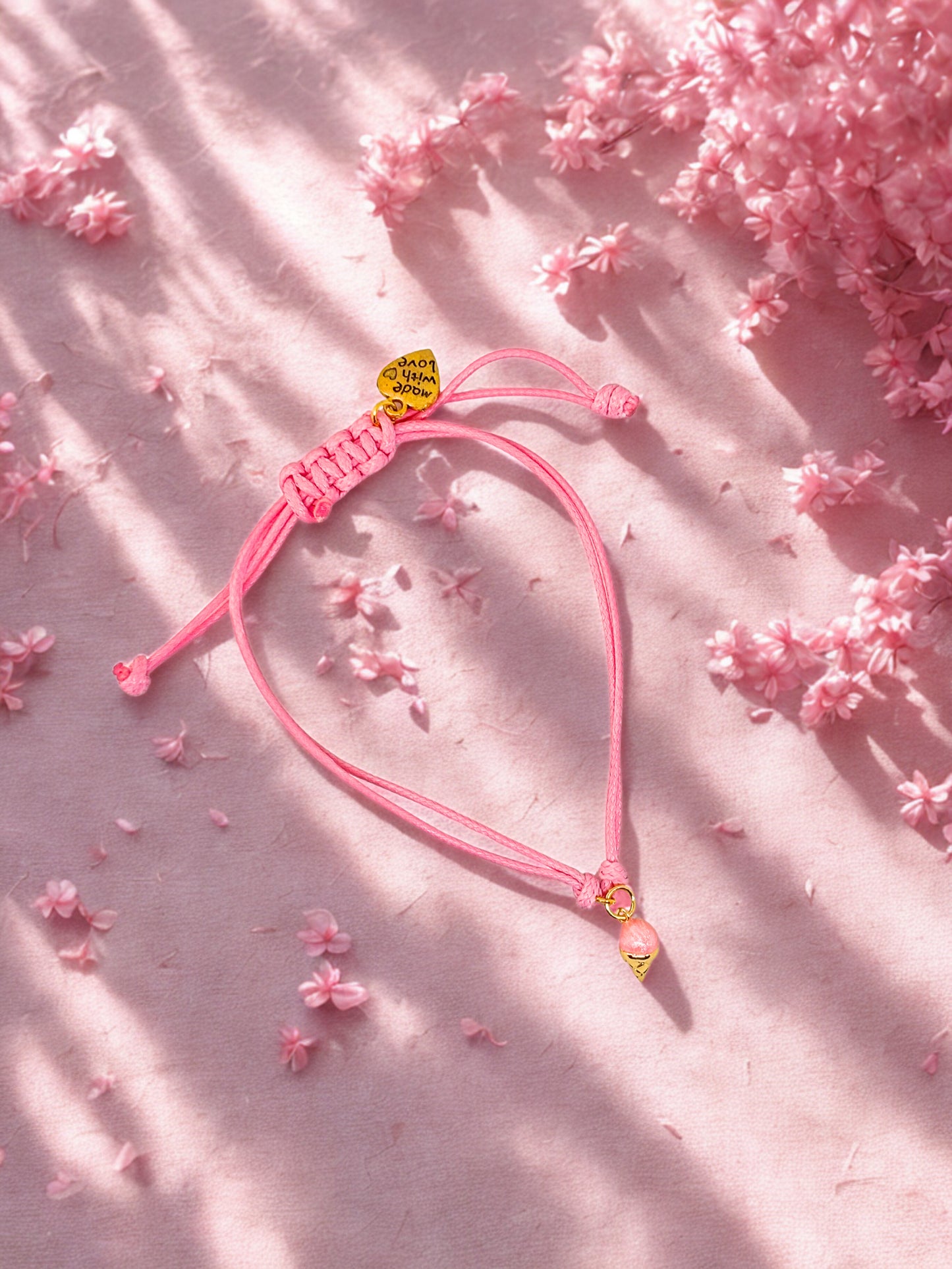 Pink cord charm bracelet with a pink and gold ice cream charm