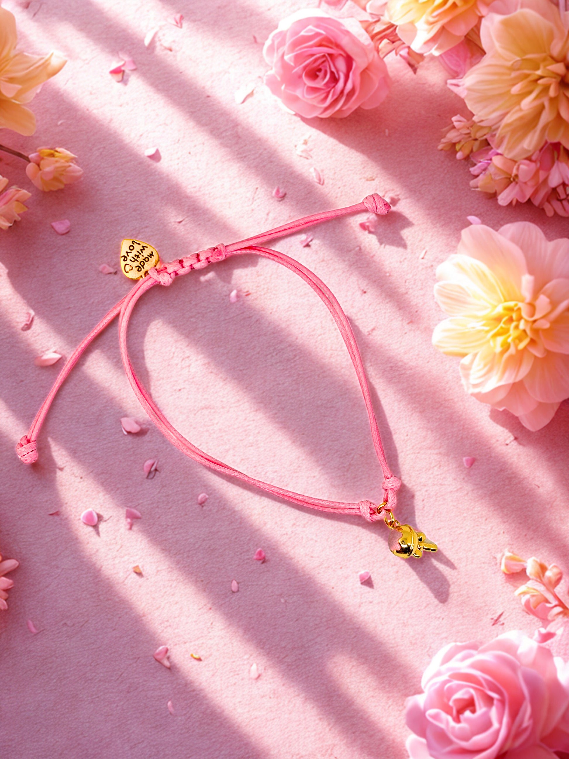 Pink cord charm bracelet with a pink and gold ice cream charm