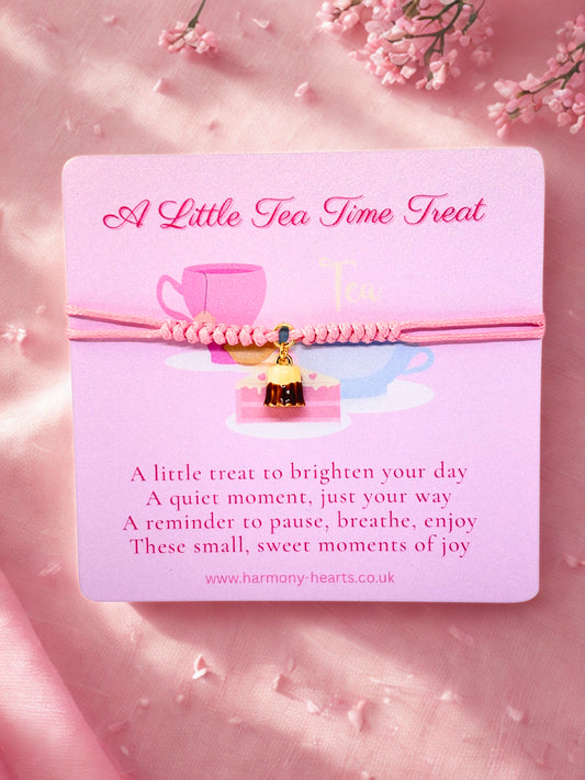 Pink cord bracelet with pudding charm presented on a pink card with tea cup design and text on a pink background with flowers