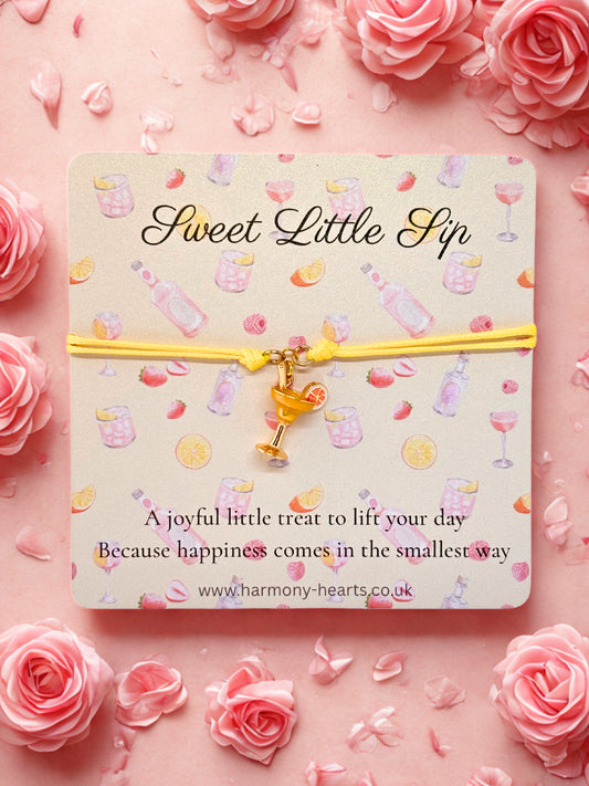 Branded Harmony Hearts card with 'Sweet Little Sip' text and a cocktail charm bracelet on a pink floral background
