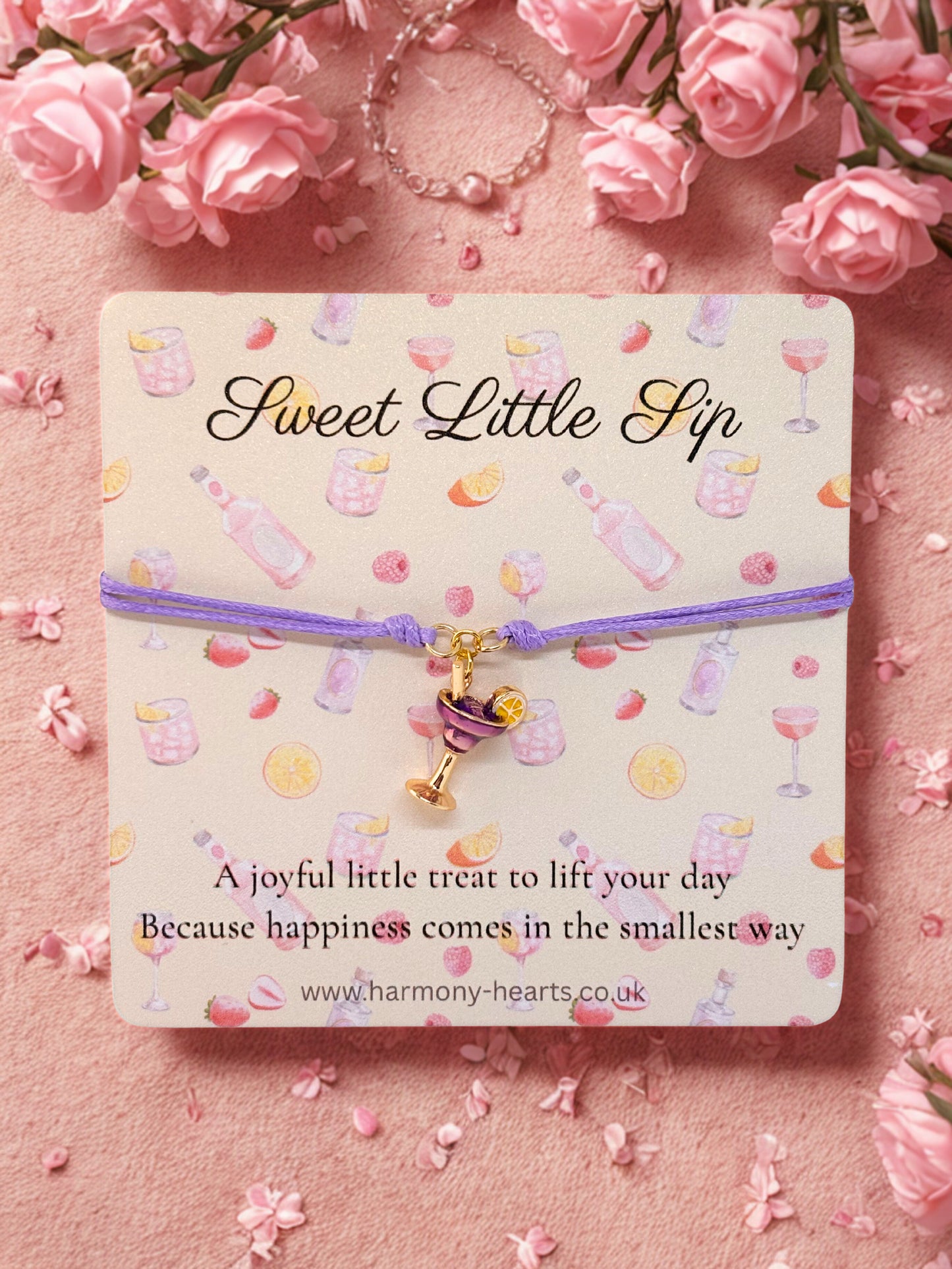 Sweet Little Slip cocktail charm bracelet on a decorative card with pink flowers in the background