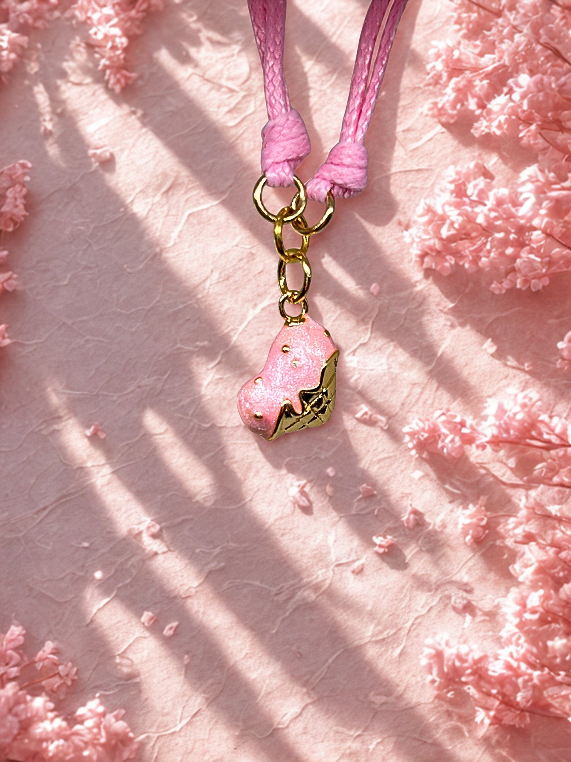 Pink charm with gold accents on a pink textured background
