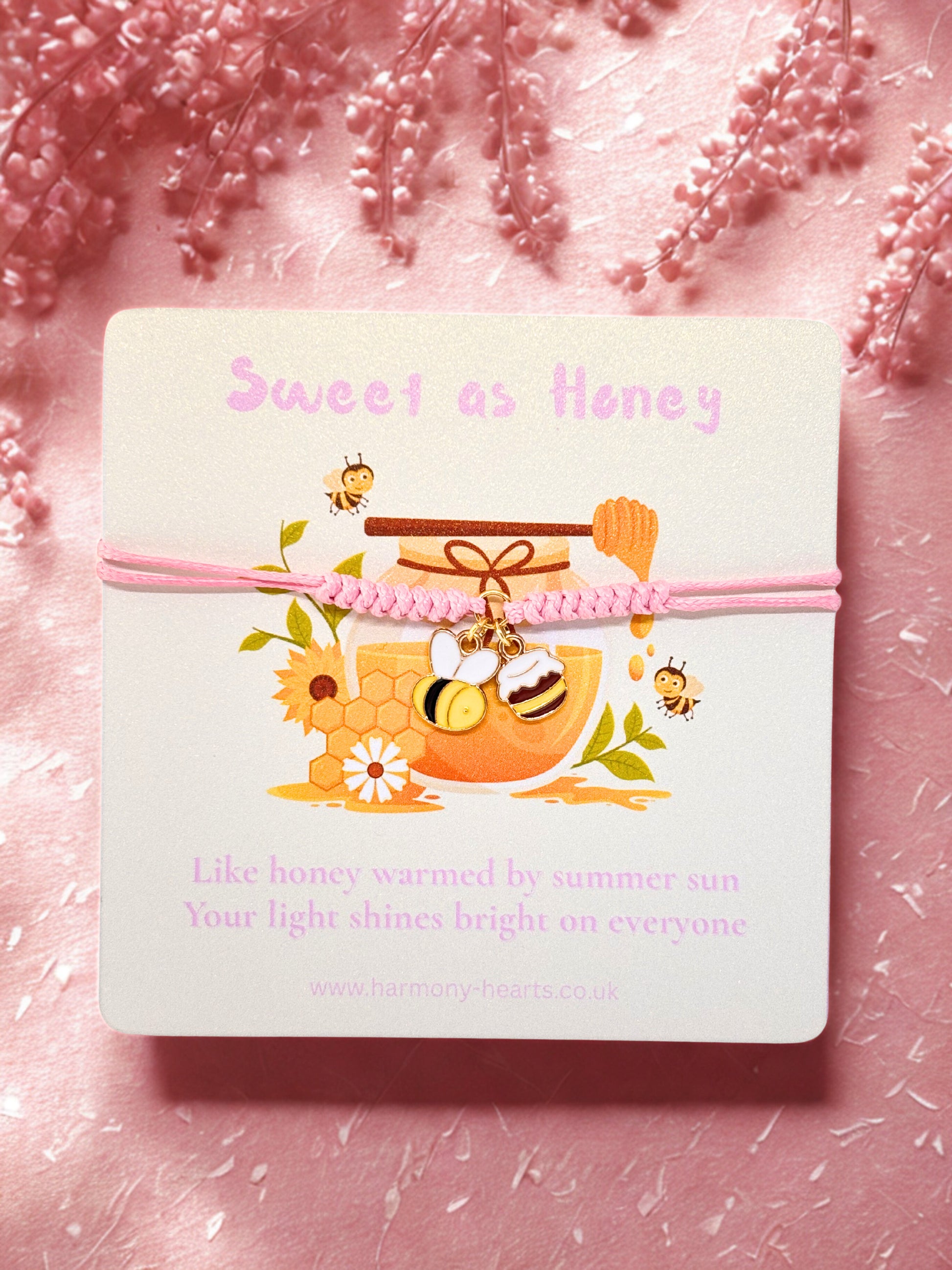Pink cord bracelet with bee and honey pot charm presented on a branded Harmony Hearts card with Sweet as Honey text