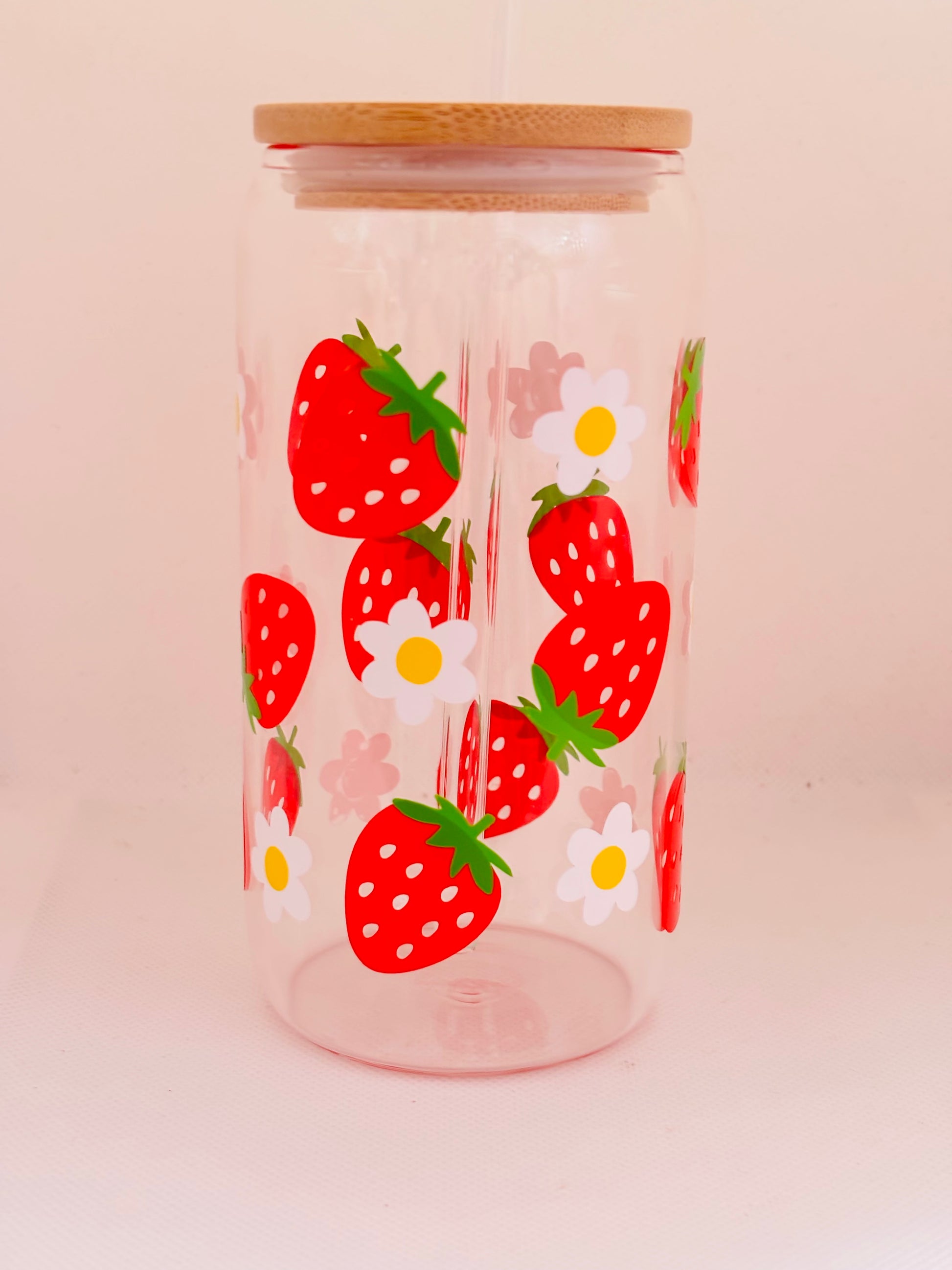 Clear glass with strawberry and daisy pattern on a light pink background