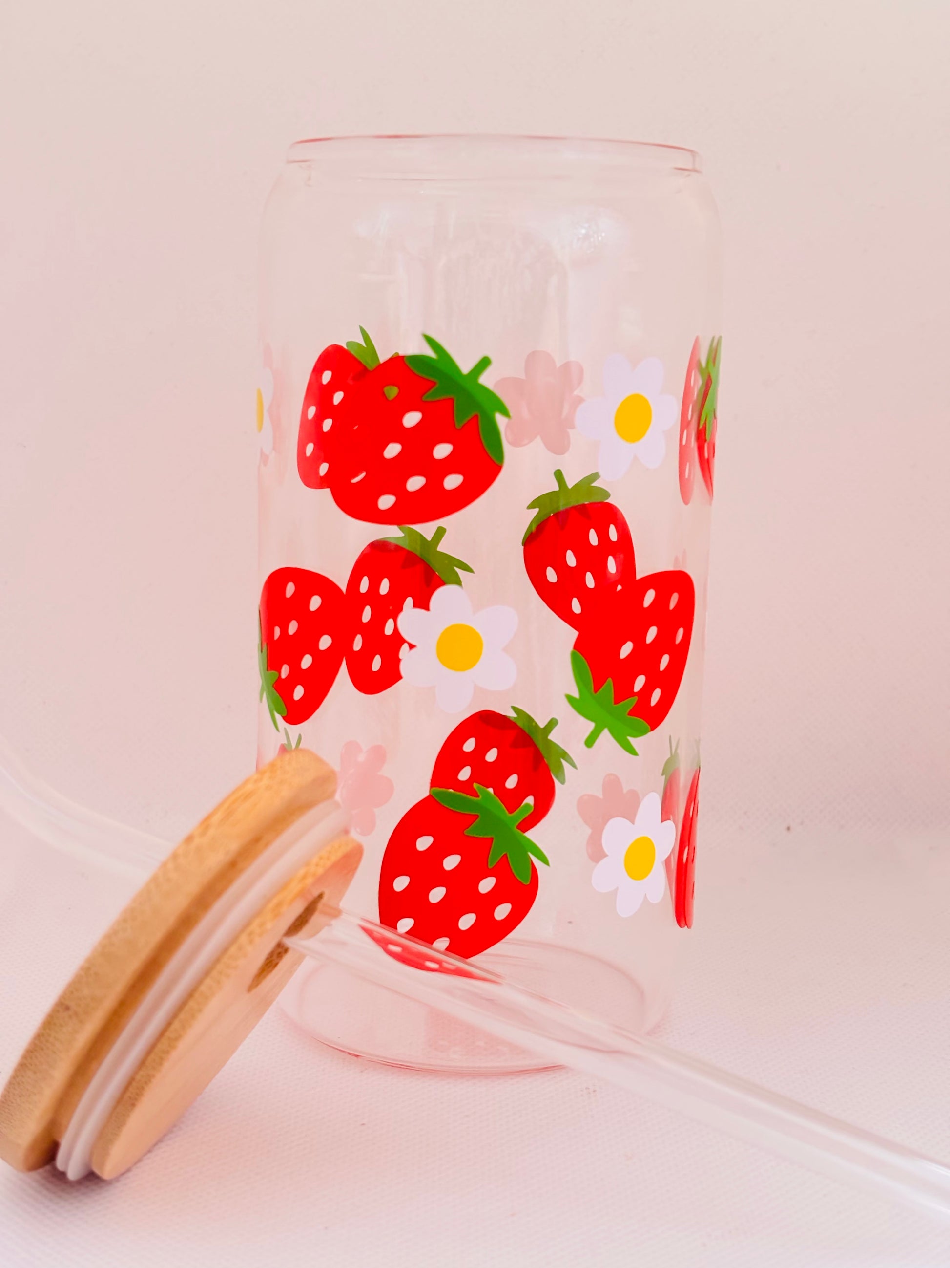 Clear glass tumbler with strawberry pattern on a light pink background