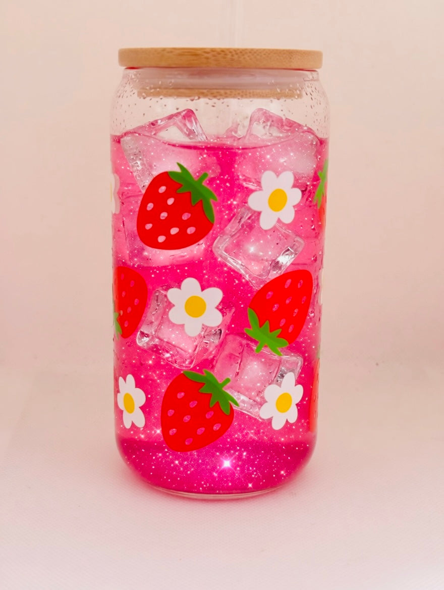 Glass with strawberry and daisy designs on a light pink background