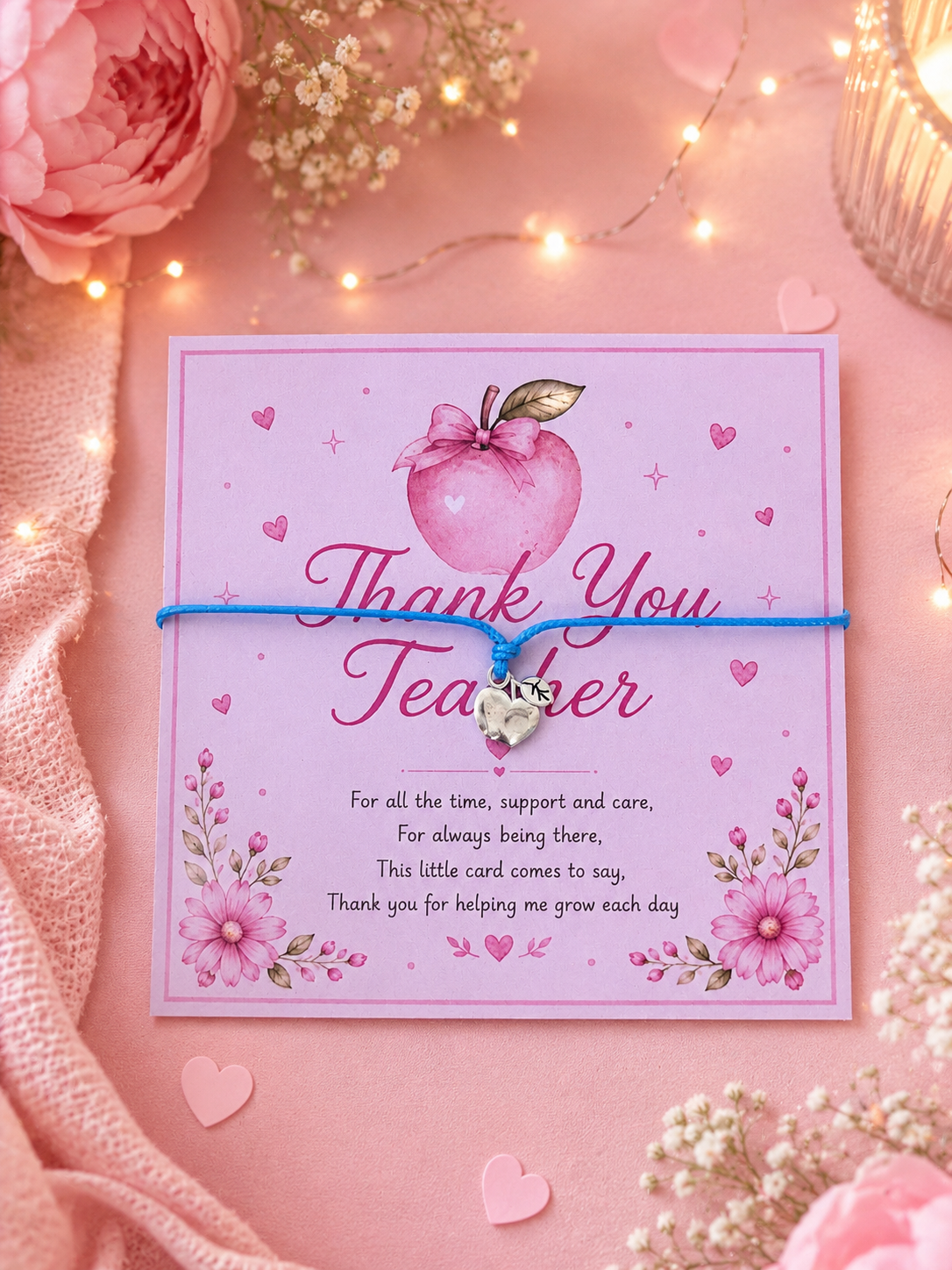 Bracelet on a pink card with 'Thank You Teacher' message, apple illustration, and decorative elements on a pink background.