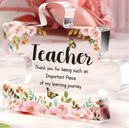 A clear acrylic puzzle piece keepsake with floral artwork and a message of appreciation for a teacher