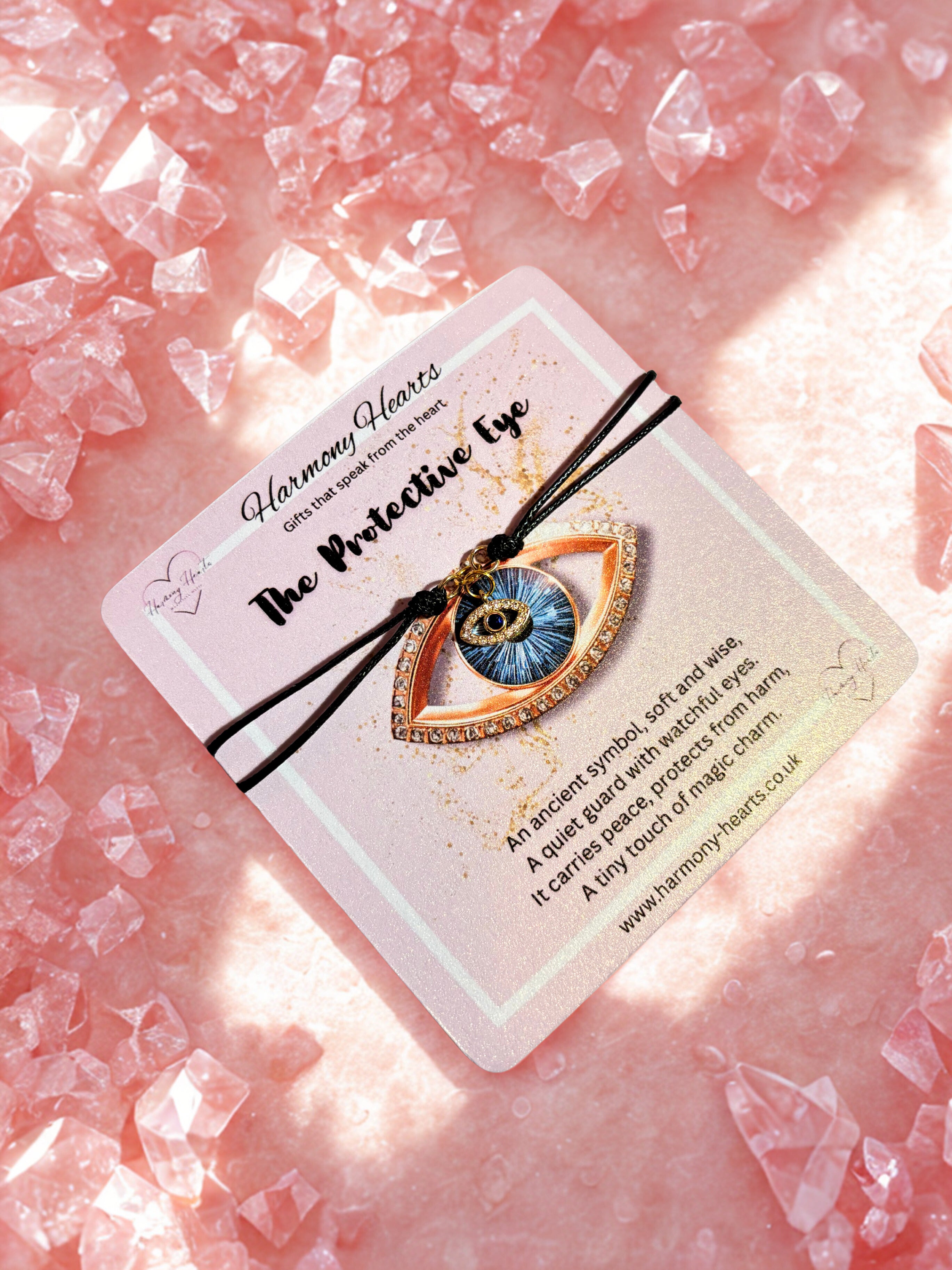 Evil eye bracelet on a card with pink crystal background