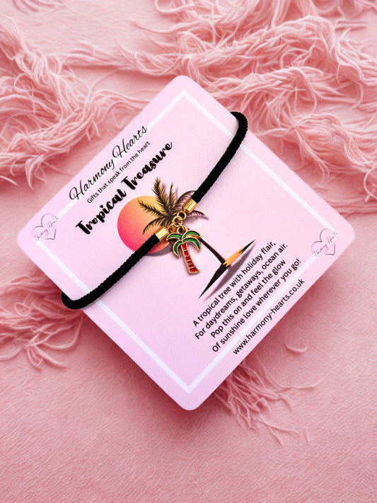 Palm tree charm bracelet on a pink card against a pink background