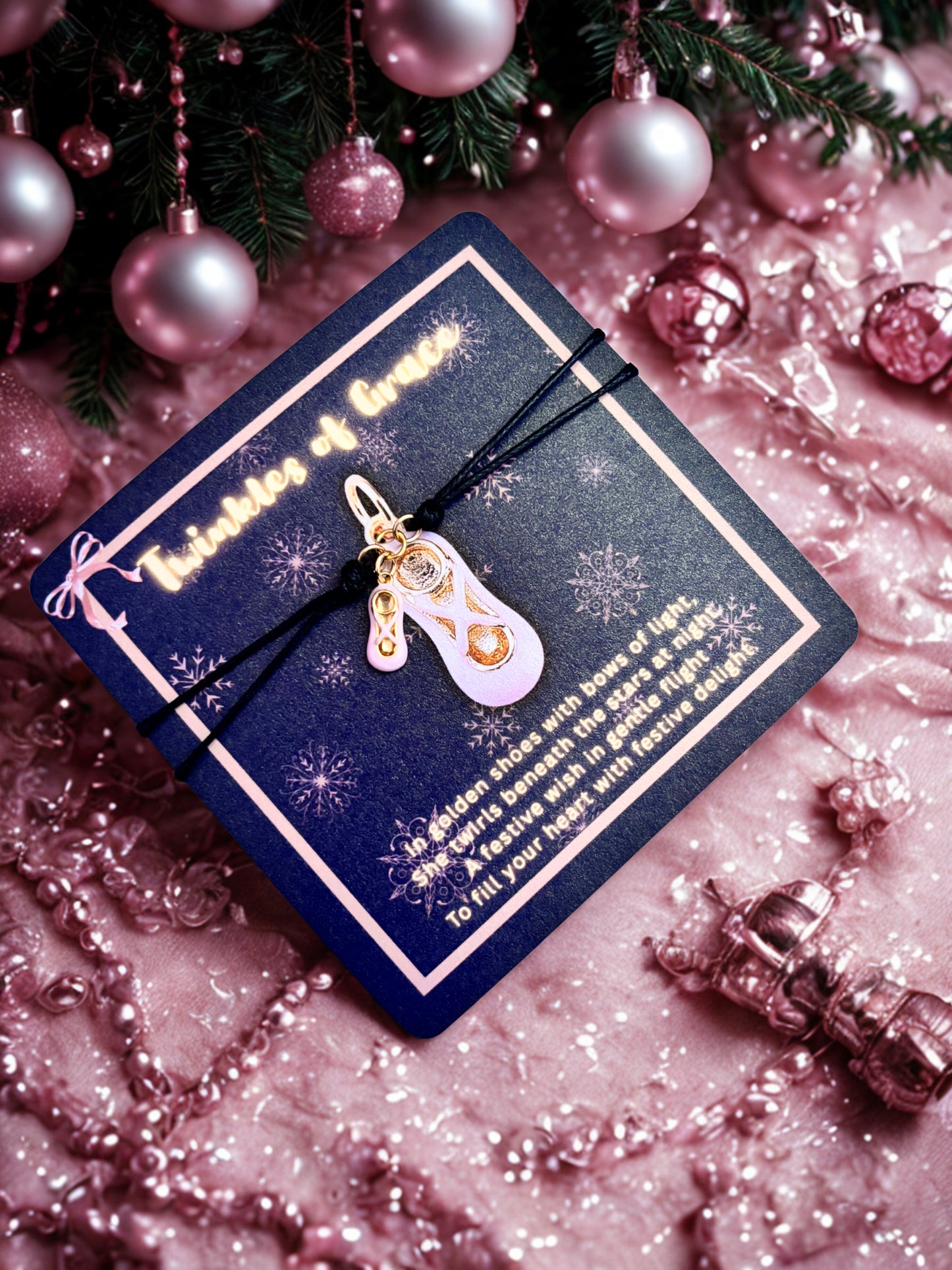 Bracelet with a pink and gold charm  on a decorative card surrounded by pink ornaments